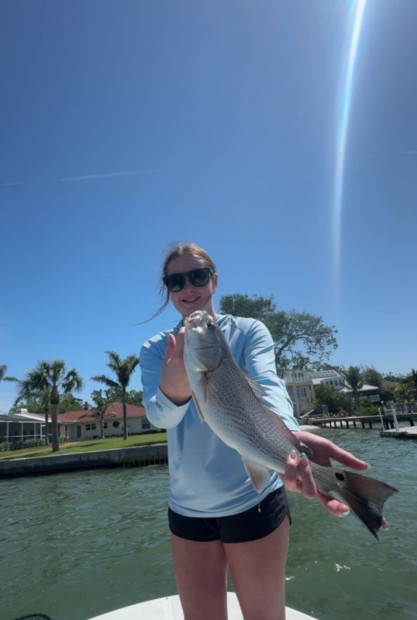 Angler holding caught fish on boat in Indian Shores FL