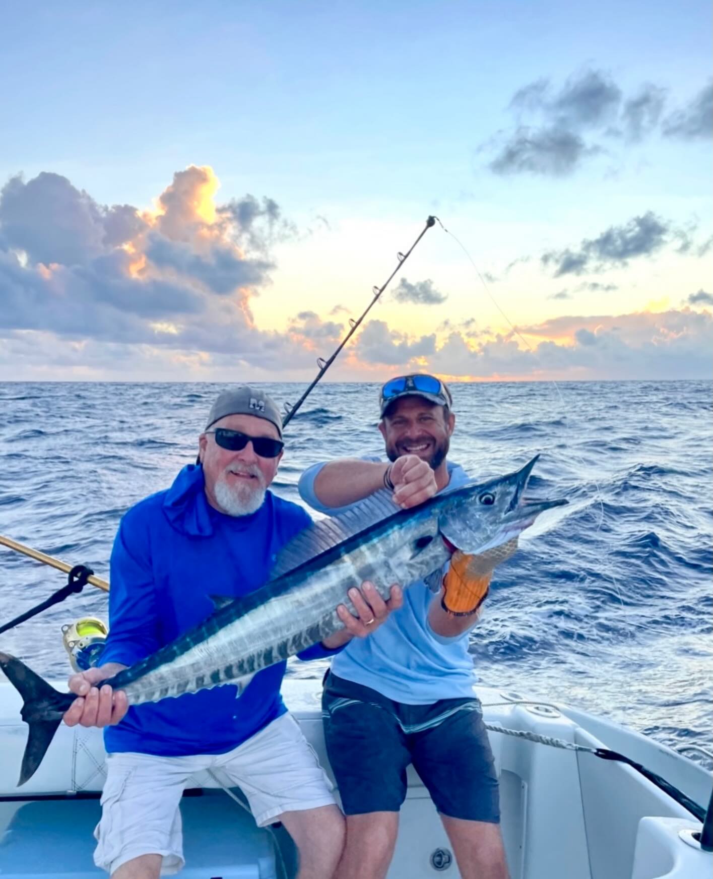 Two anglers holding a fresh caught wahoo fish on fishing boat in Christiansted St. Croix waters