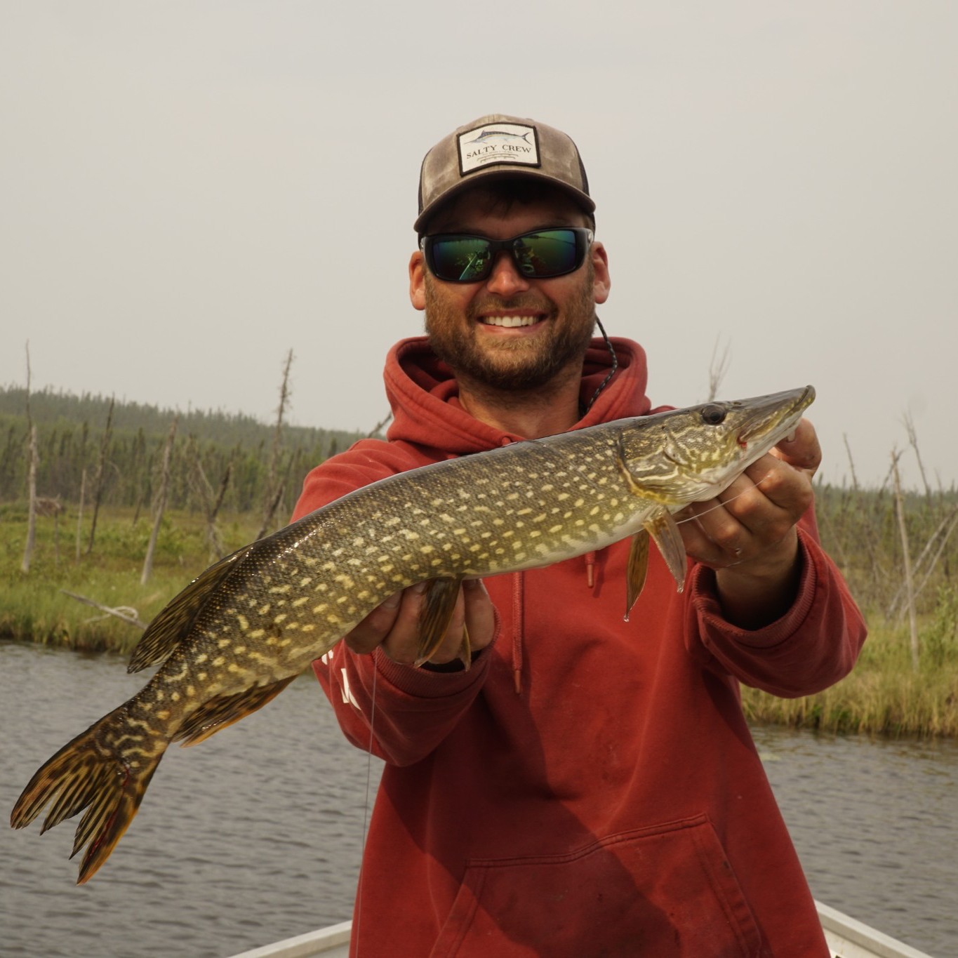Angler holding a large Northern Pike fish in the South Slave Region