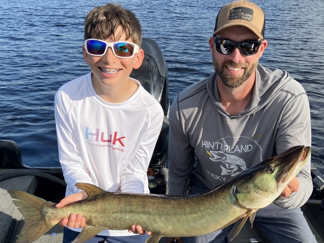 Three anglers on Wisconsin lake fishing for musky from guided charter boat with professional guide