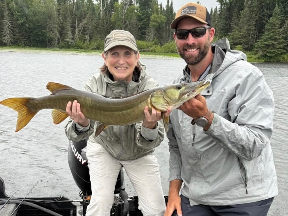Wisconsin musky fishing charter boat with 3 anglers and guide on lake, half-day trip