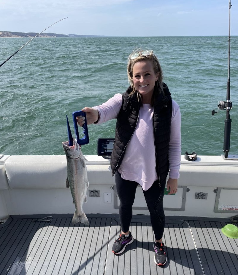 A fisherman holding a coho salmon catch in South Haven