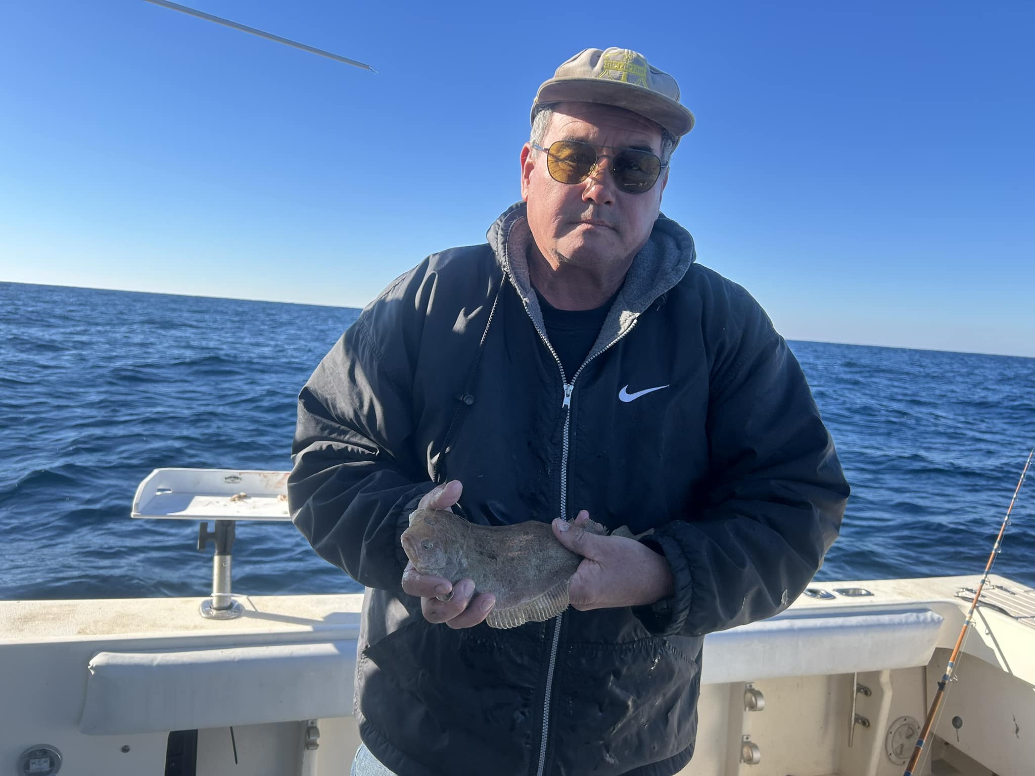 Angler holding freshly caught flatfish on fishing boat in Pensacola Beach FL waters