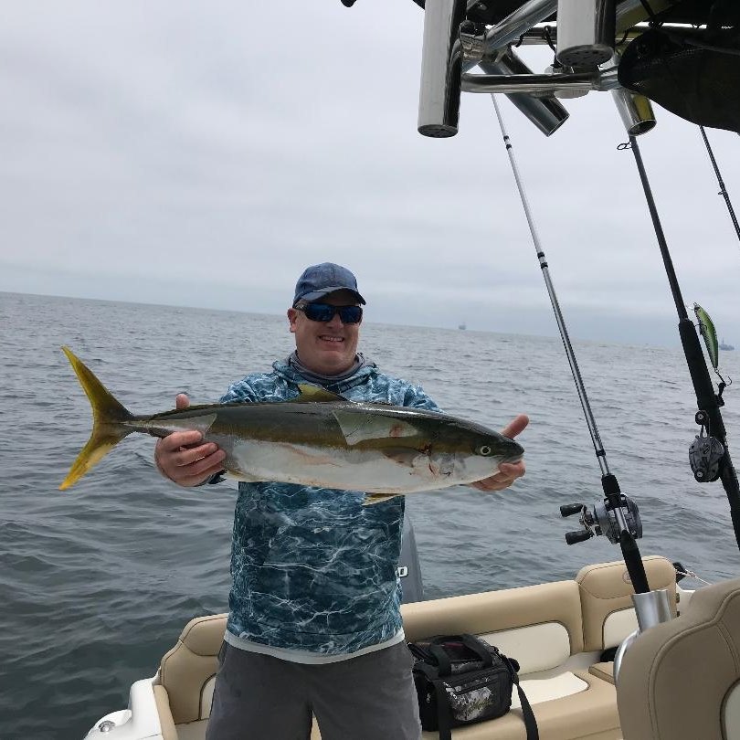 A fisherman holding a large mahi mahi or common dolphinfish in Long Beach