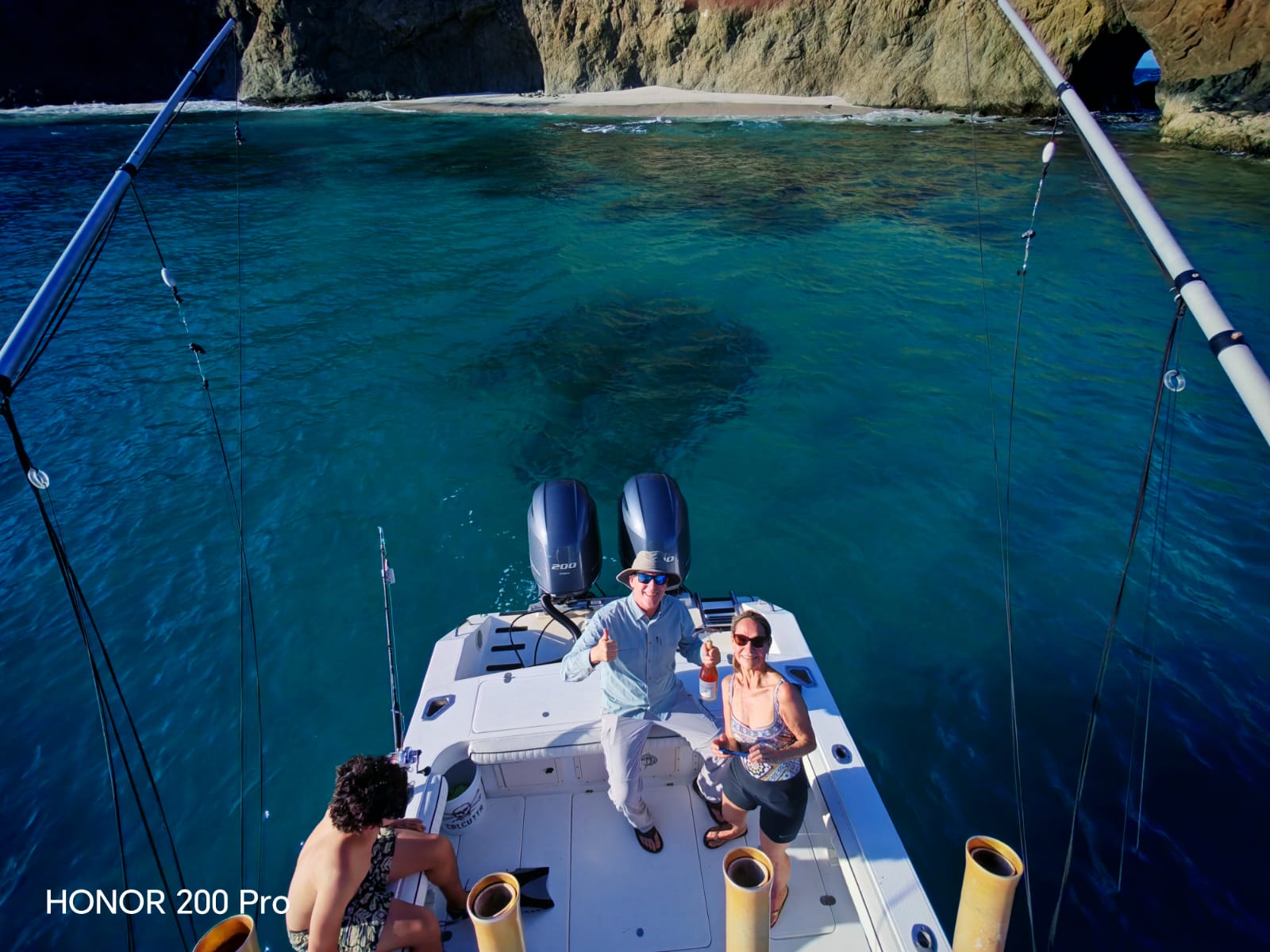 Fishing boat anchored in turquoise waters near rocky cliffs in Guanacaste