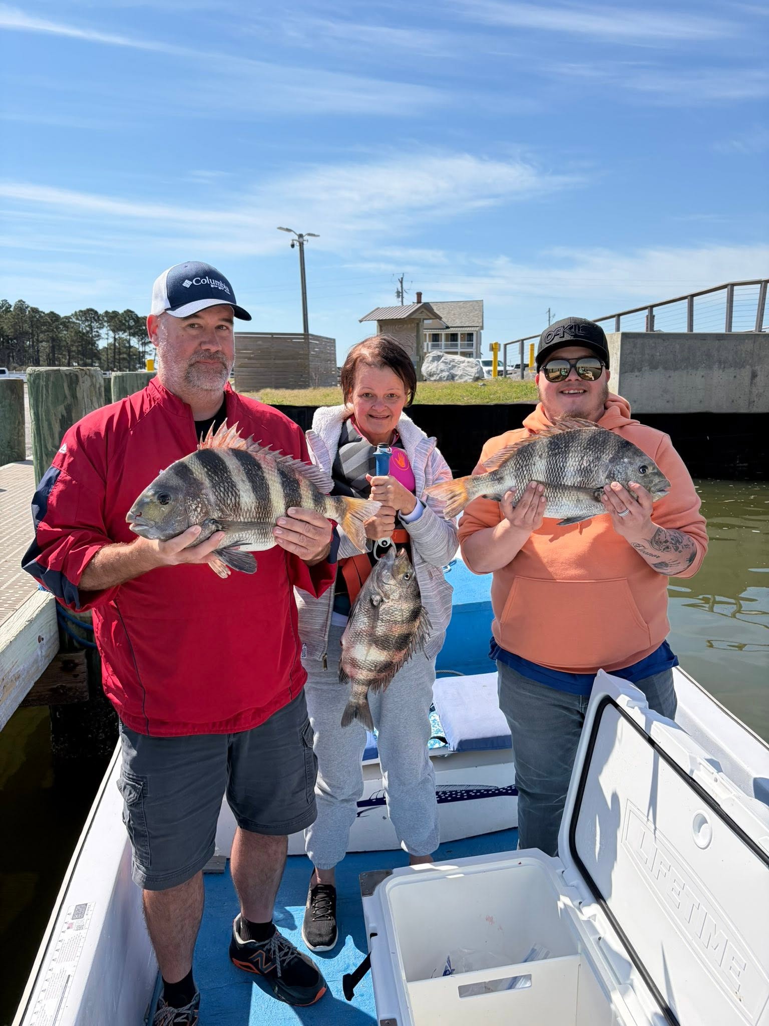 Three anglers displaying freshly caught sheepshead fish on fishing boat in Gulf Shores AL
