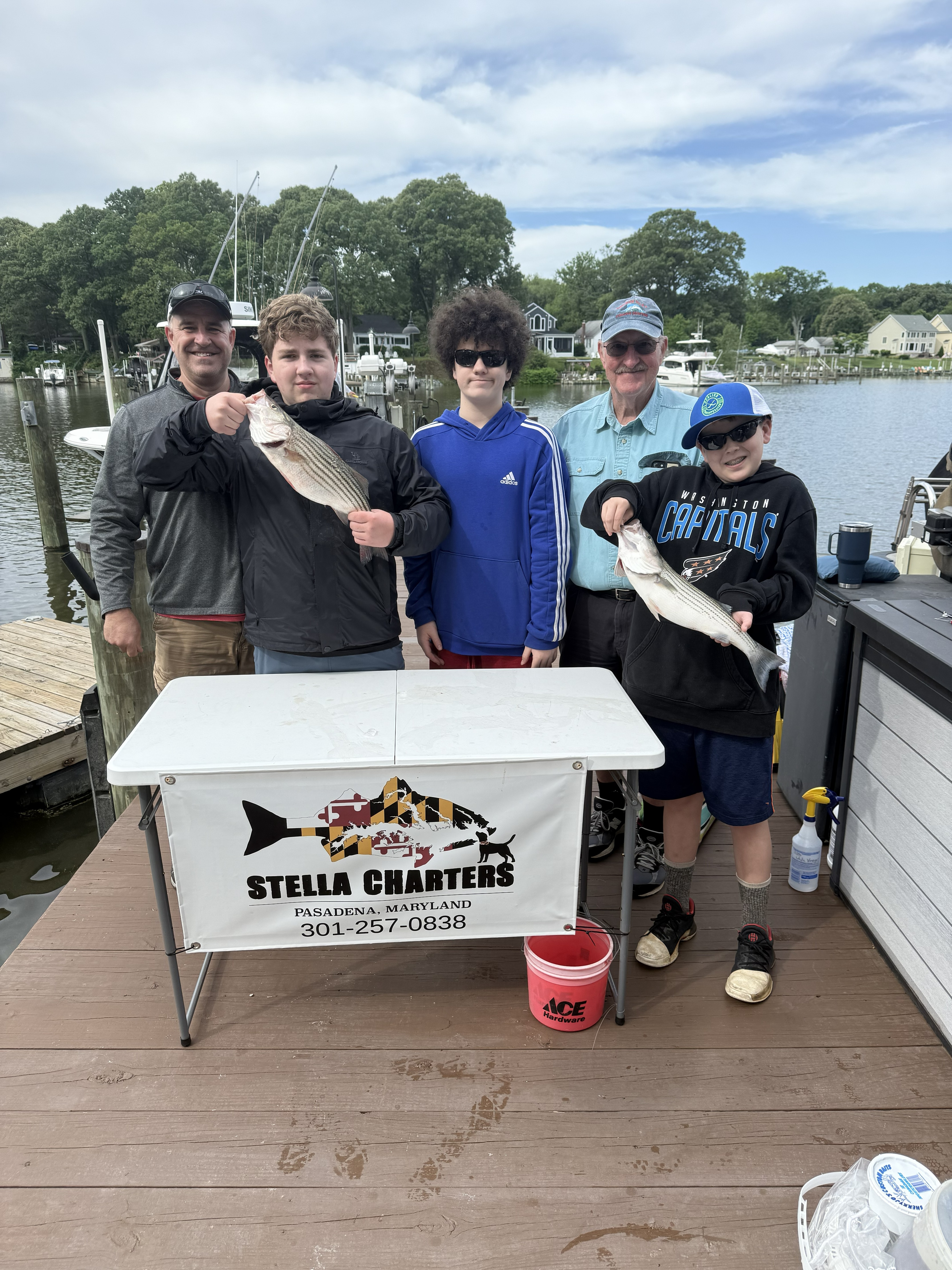Successful striped bass fishing trip in Pasadena MD with fresh caught fish displayed on dock