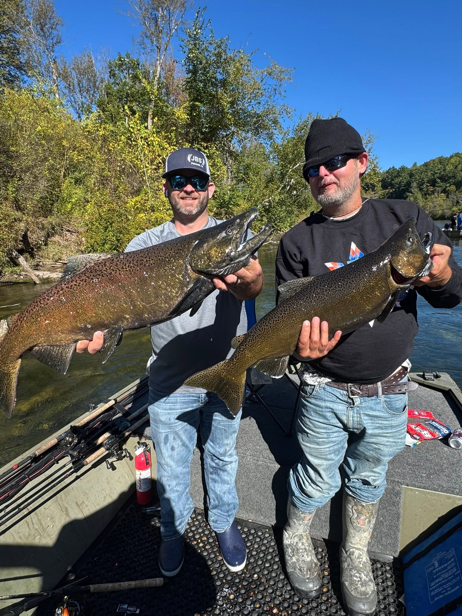 Two anglers displaying caught Chinook salmon on fishing boat in Brethren Michigan