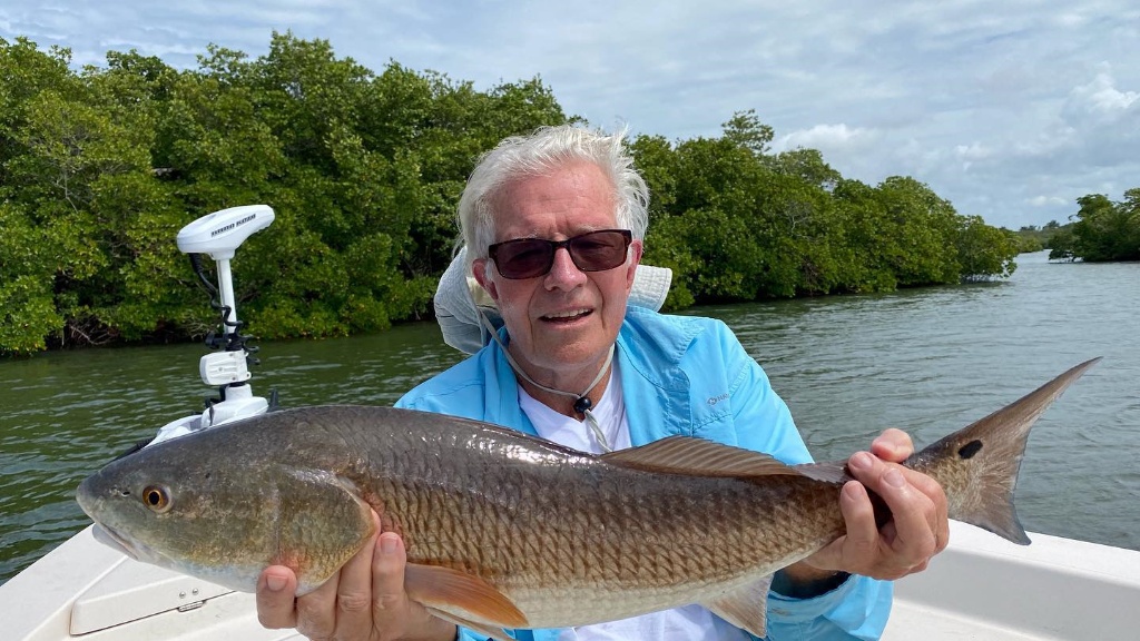 A solo angler standing in the waters of Naples