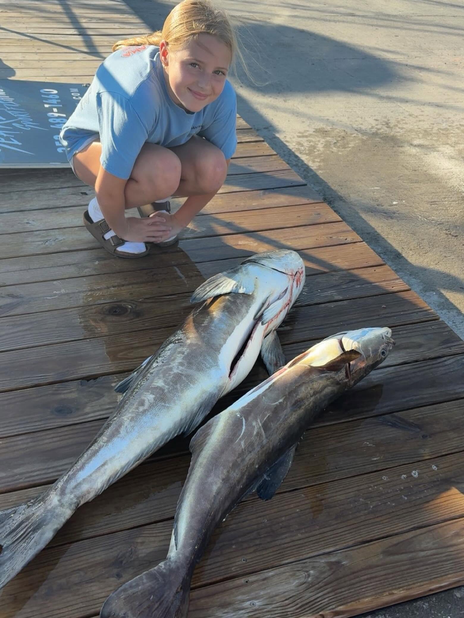 Two large fish caught fishing in Wanchese NC displayed on wooden dock