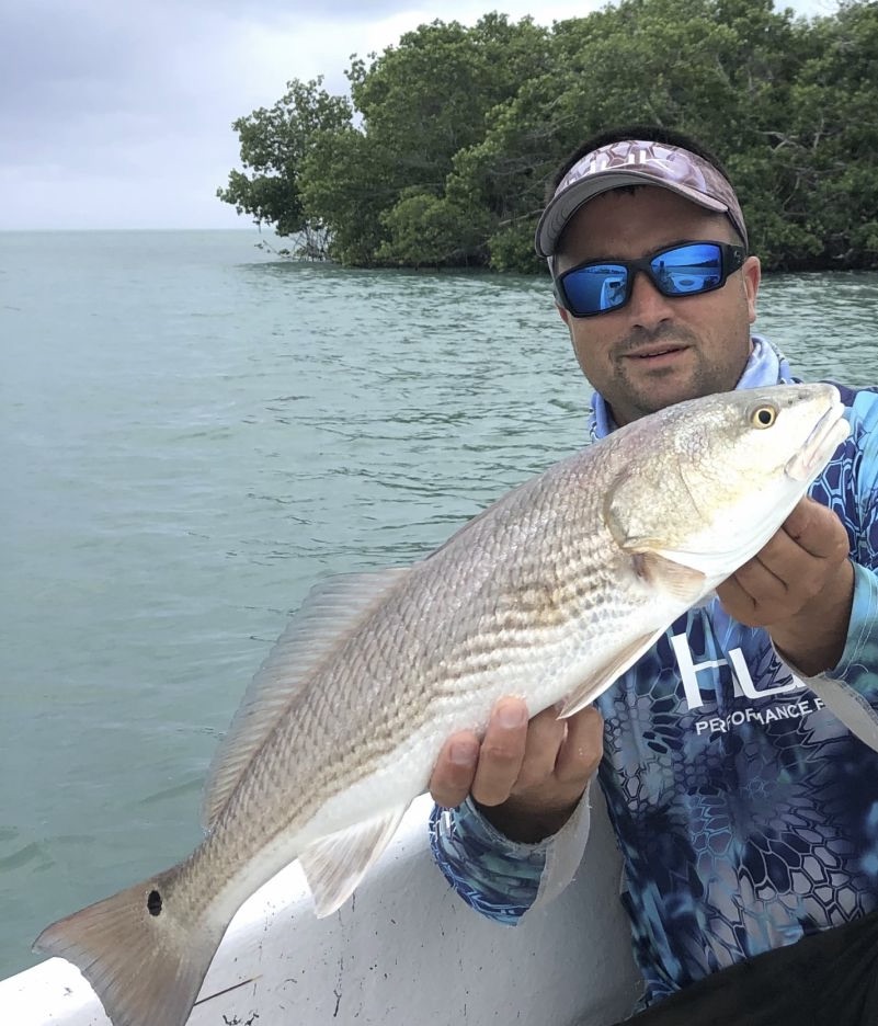 Fisherman holding a large redfish in Florida