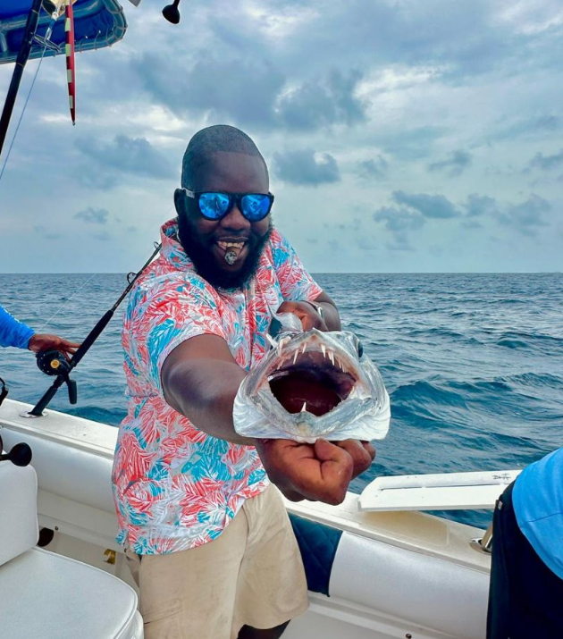 A person fishing in Nassau, with a single fish caught