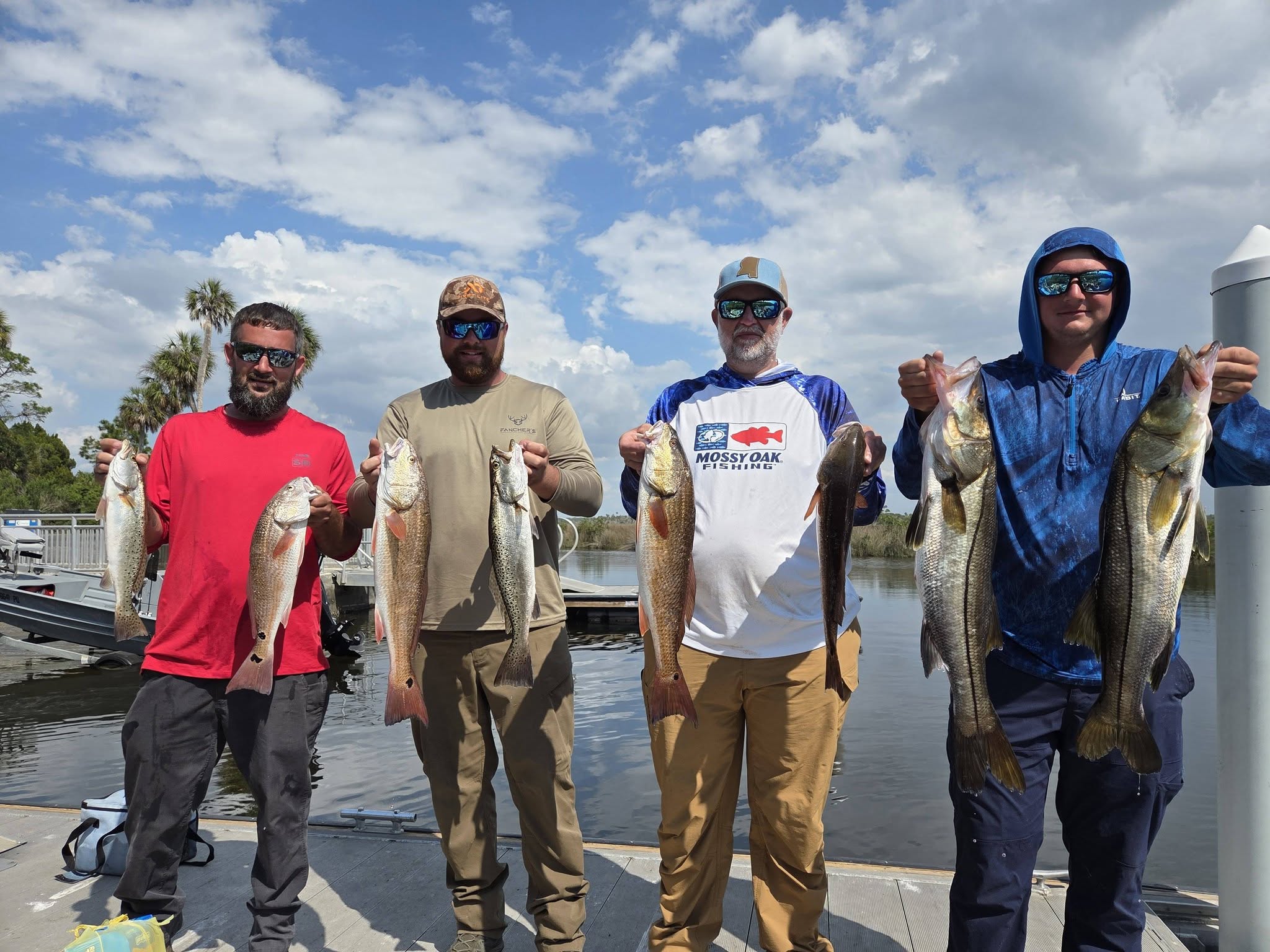 Successful fishing trip in Bayport FL with caught snook, redfish, and speckled trout displayed at marina dock