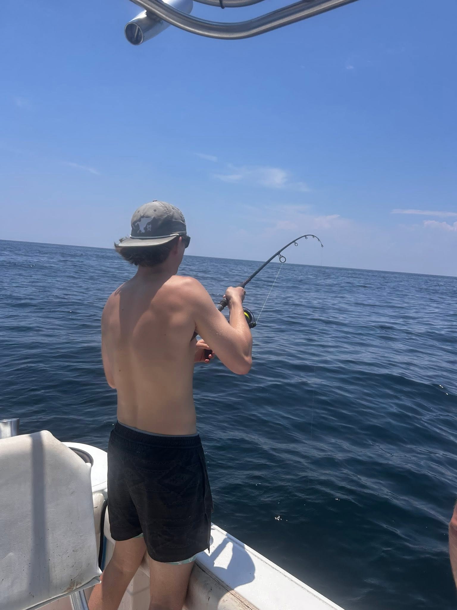 Deep sea fishing with bent rod indicating fish on the line from boat in Midway GA waters