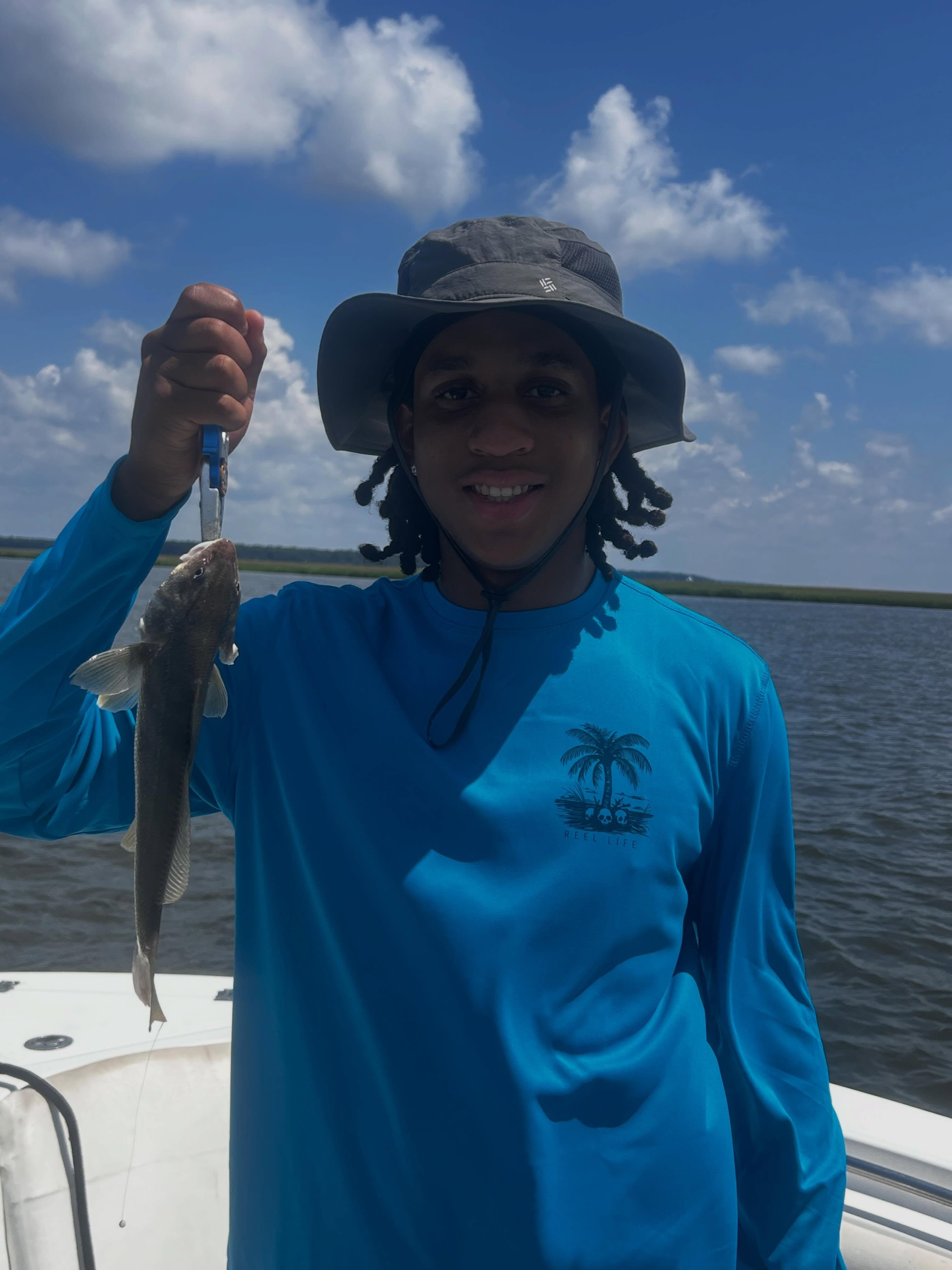 Angler holding caught fish on fishing charter boat in Midway GA waters