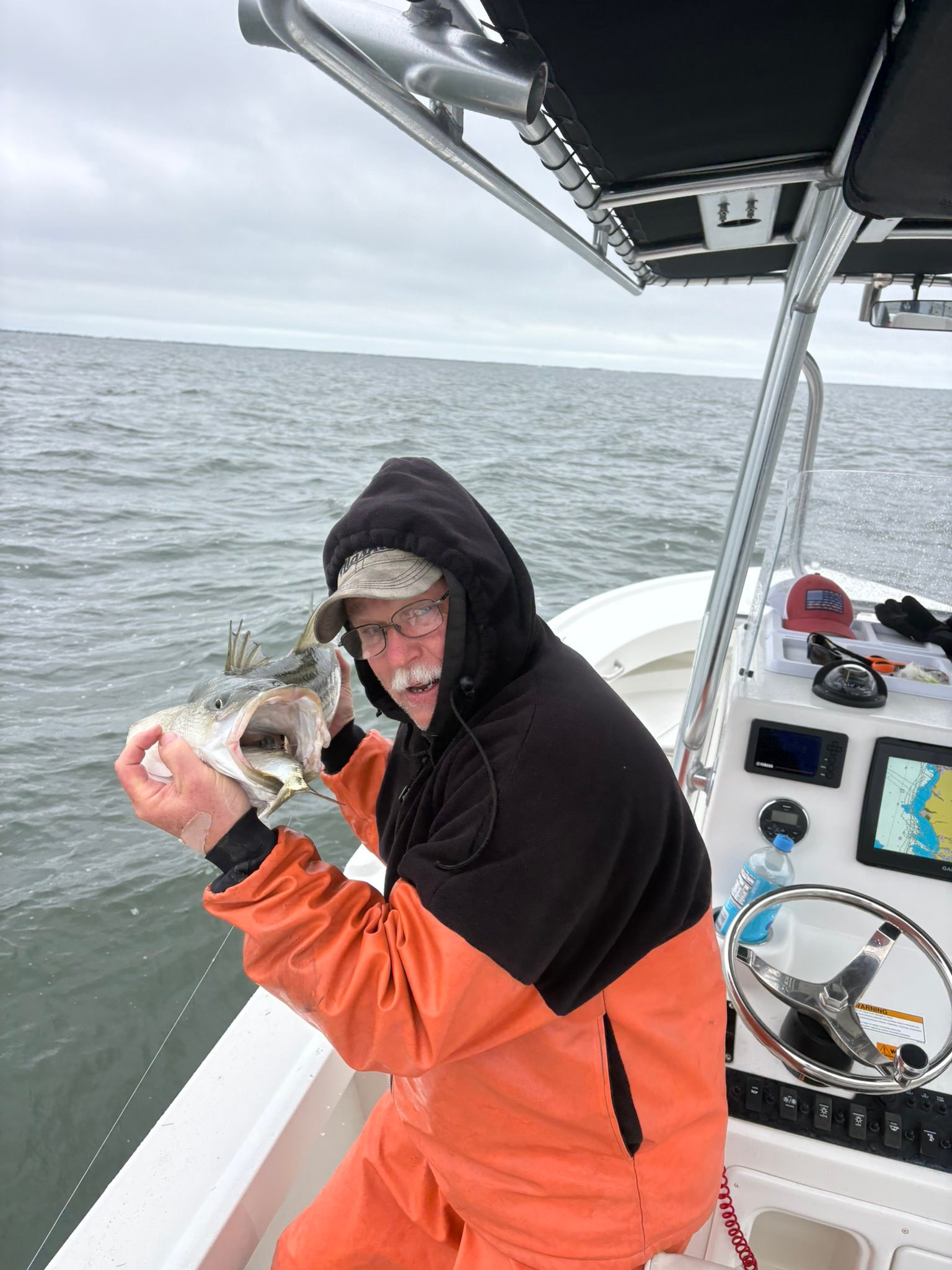 Angler holding freshly caught fish on fishing boat in Mastic Beach NY waters
