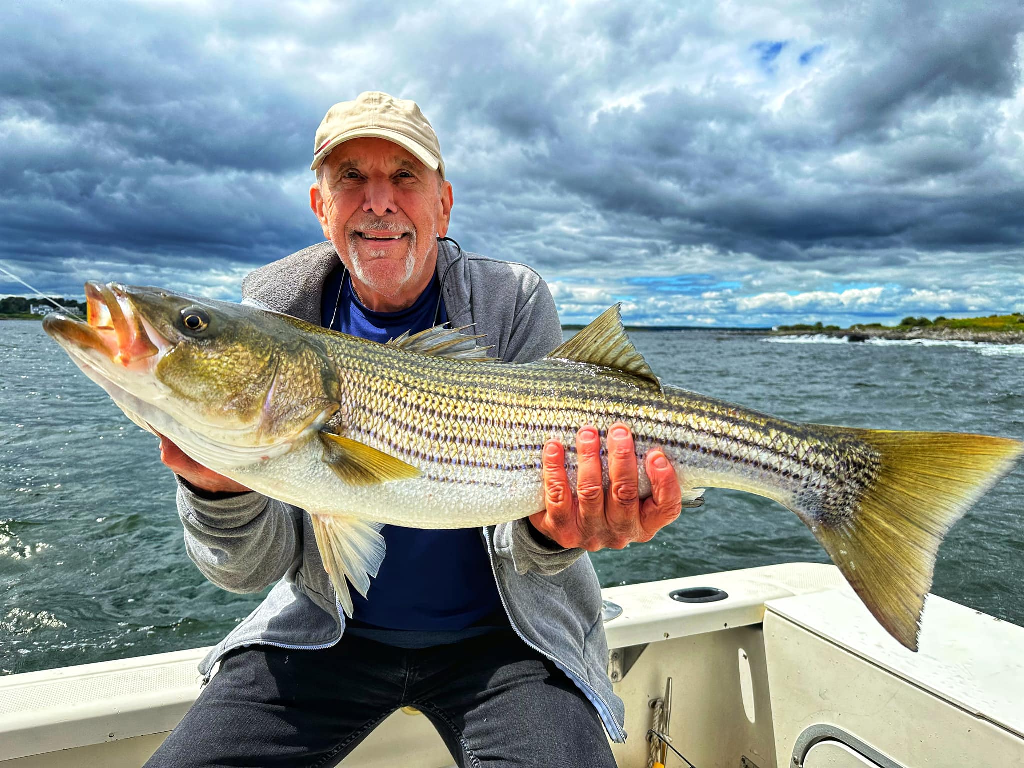 Angler proudly holding a huge striped bass in Saco