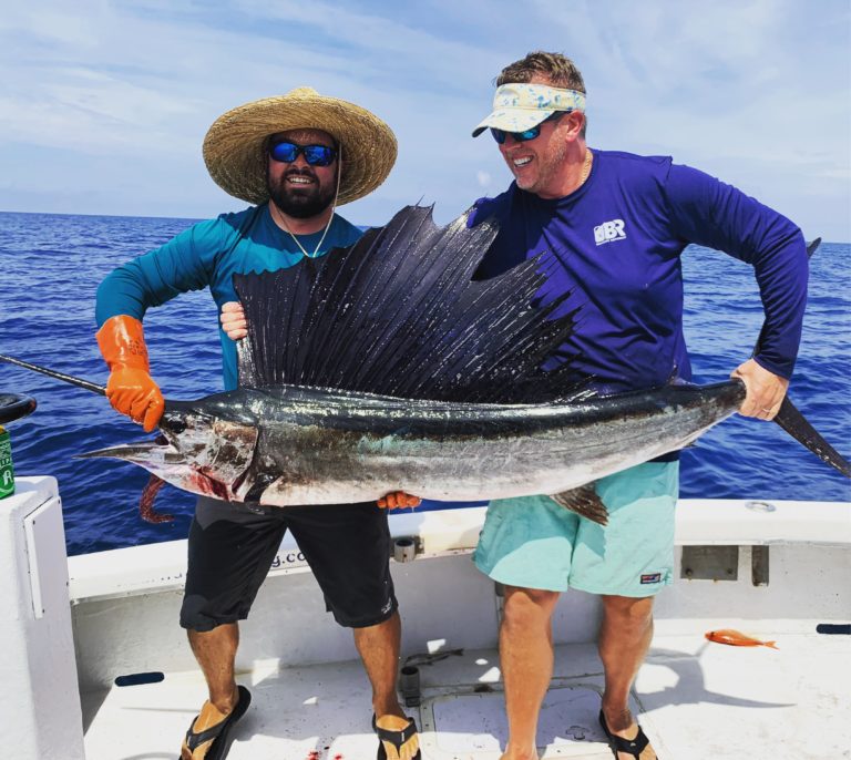 Two anglers reeling in an Atlantic Sailfish in FL