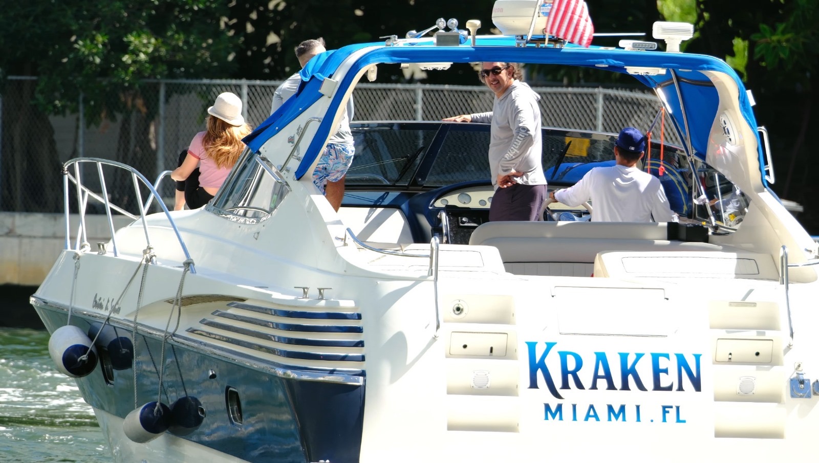 White and blue boat named Kraken docked in Miami FL with blue canopy and multiple engines