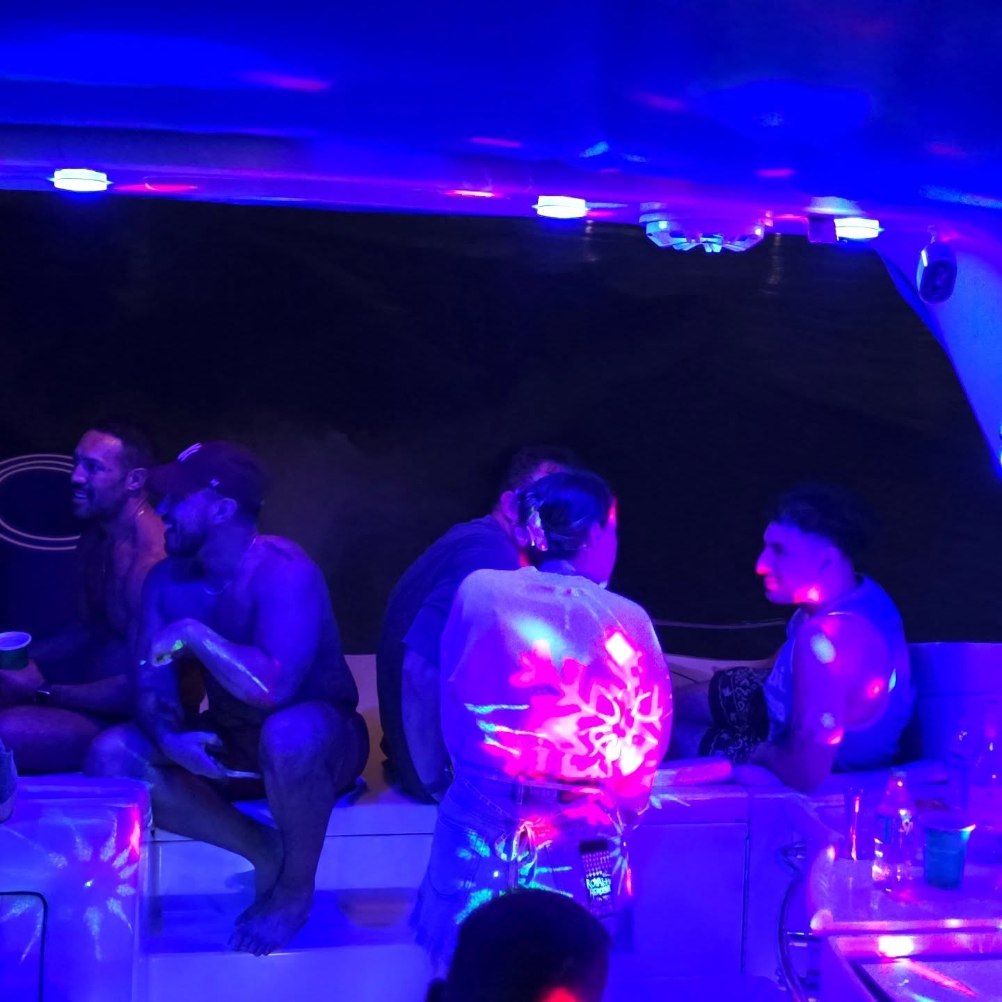 Miami night yacht charter with glowing city skyline, luxury party boat cruise for 13 guests