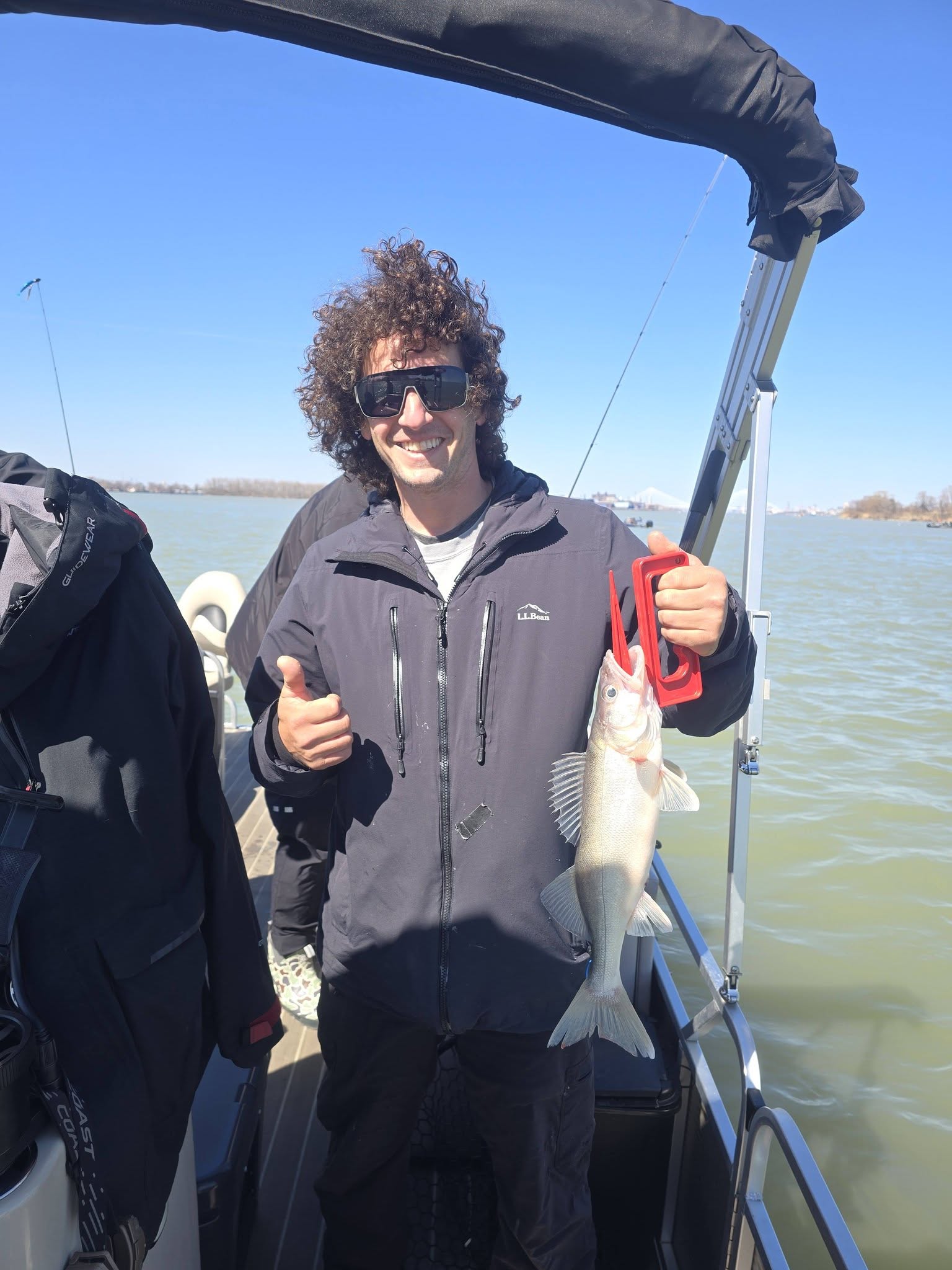 Angler holding freshly caught fish on fishing boat in Monroe Michigan waters