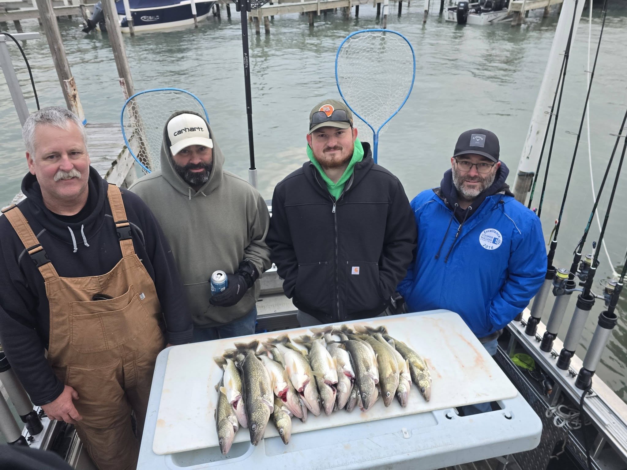 Four anglers display their walleye catch on fishing boat in Monroe MI