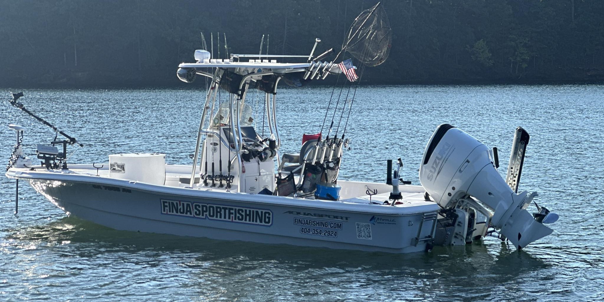 White fishing charter boat with outboard motor and fishing equipment on water in Gainesville GA