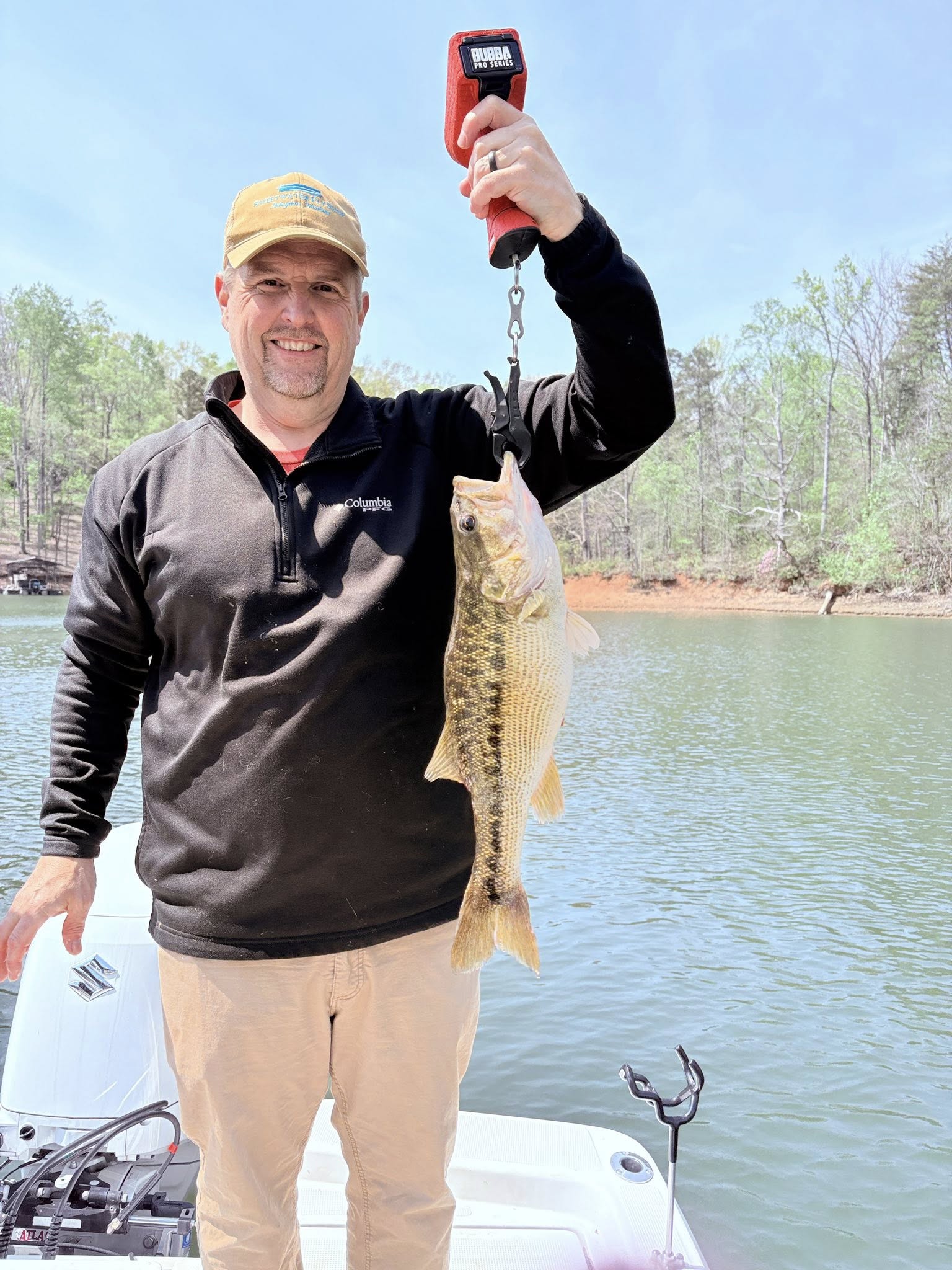 Spotted bass being weighed on digital scale after successful fishing trip in Gainesville GA