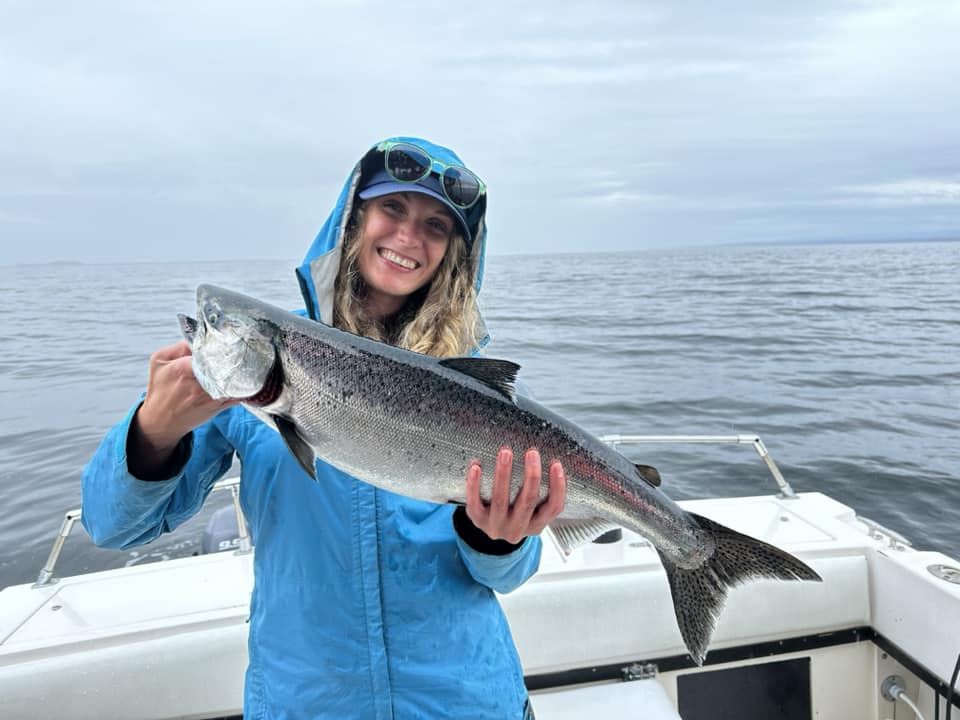 A person fishing in BC, with a large 27-inch fish