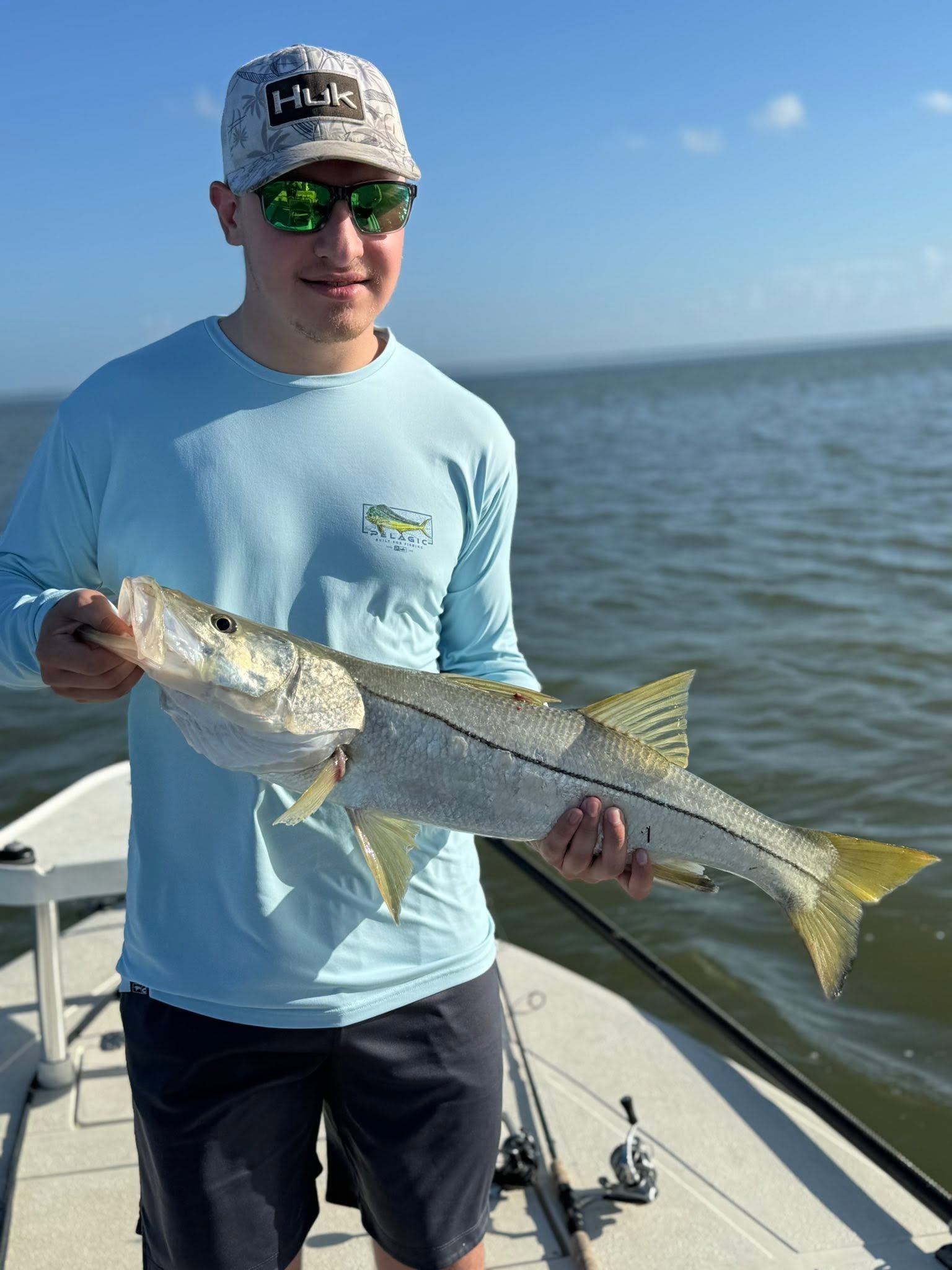 Angler holding caught snook on fishing boat in Tavernier FL waters