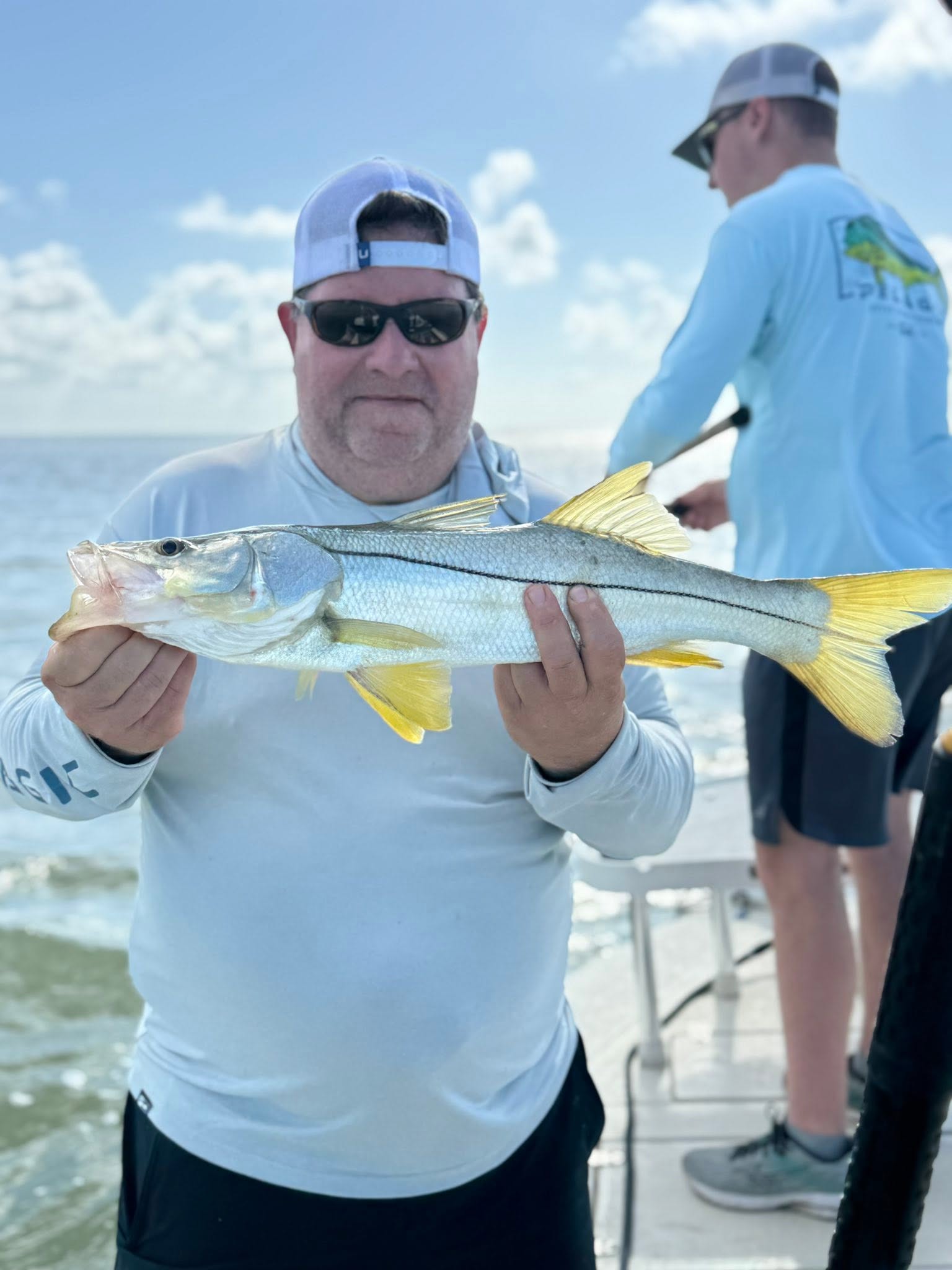 Angler holding freshly caught snook on fishing charter boat in Tavernier Florida