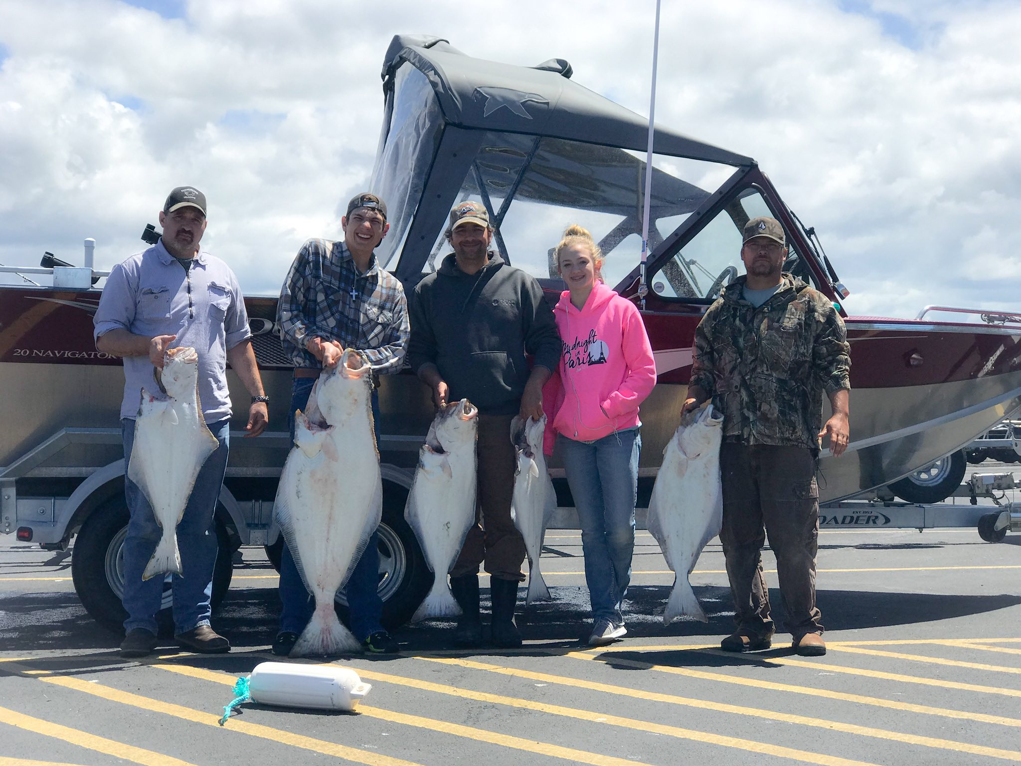 Five Pacific Halibut displayed after successful fishing trip in Charleston OR with boat and trailer in background