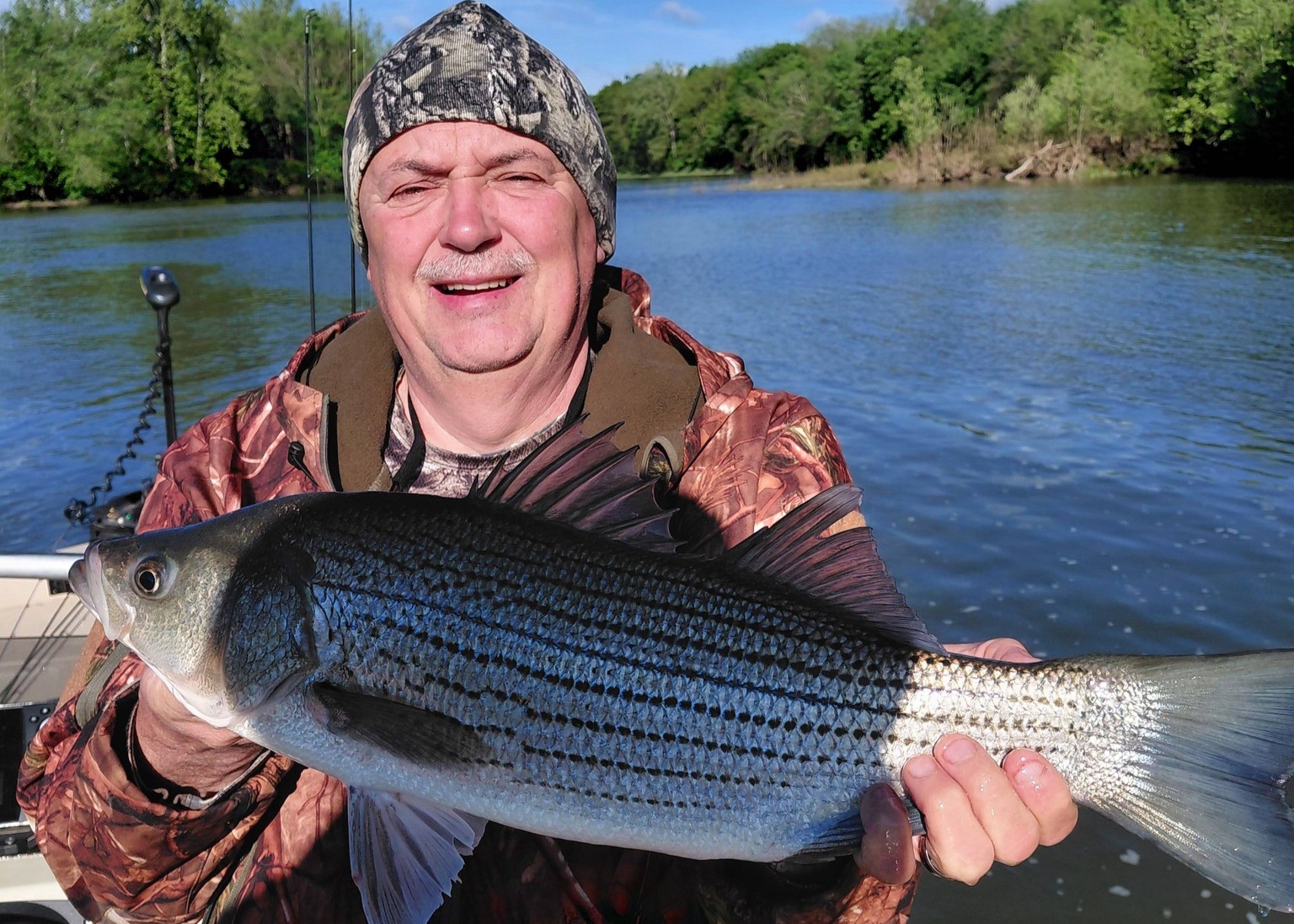 Angler holding striped bass catch on boat in Forest Inn PA