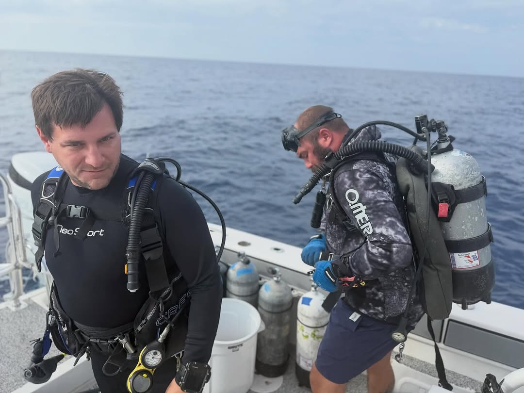 Scuba divers preparing diving equipment on fishing boat in Ocala FL waters