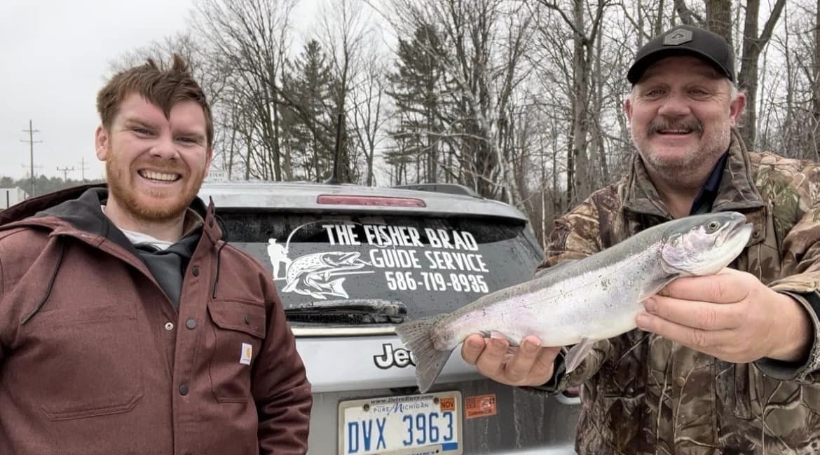 Angler holding a 15-inch rainbow trout in Port Huron