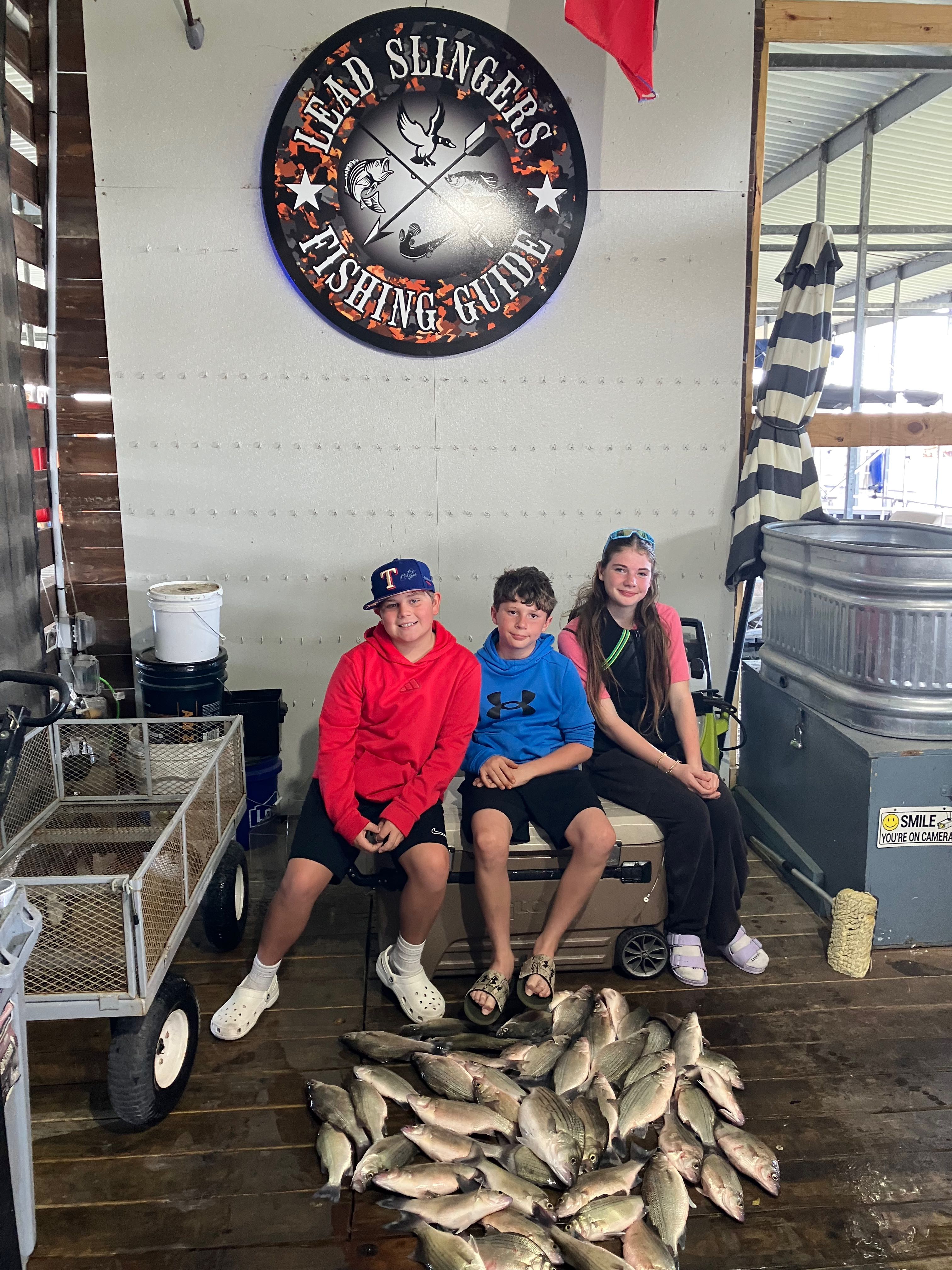 Successful fishing trip in Forney TX showing large catch of fish displayed on dock at fishing guide service