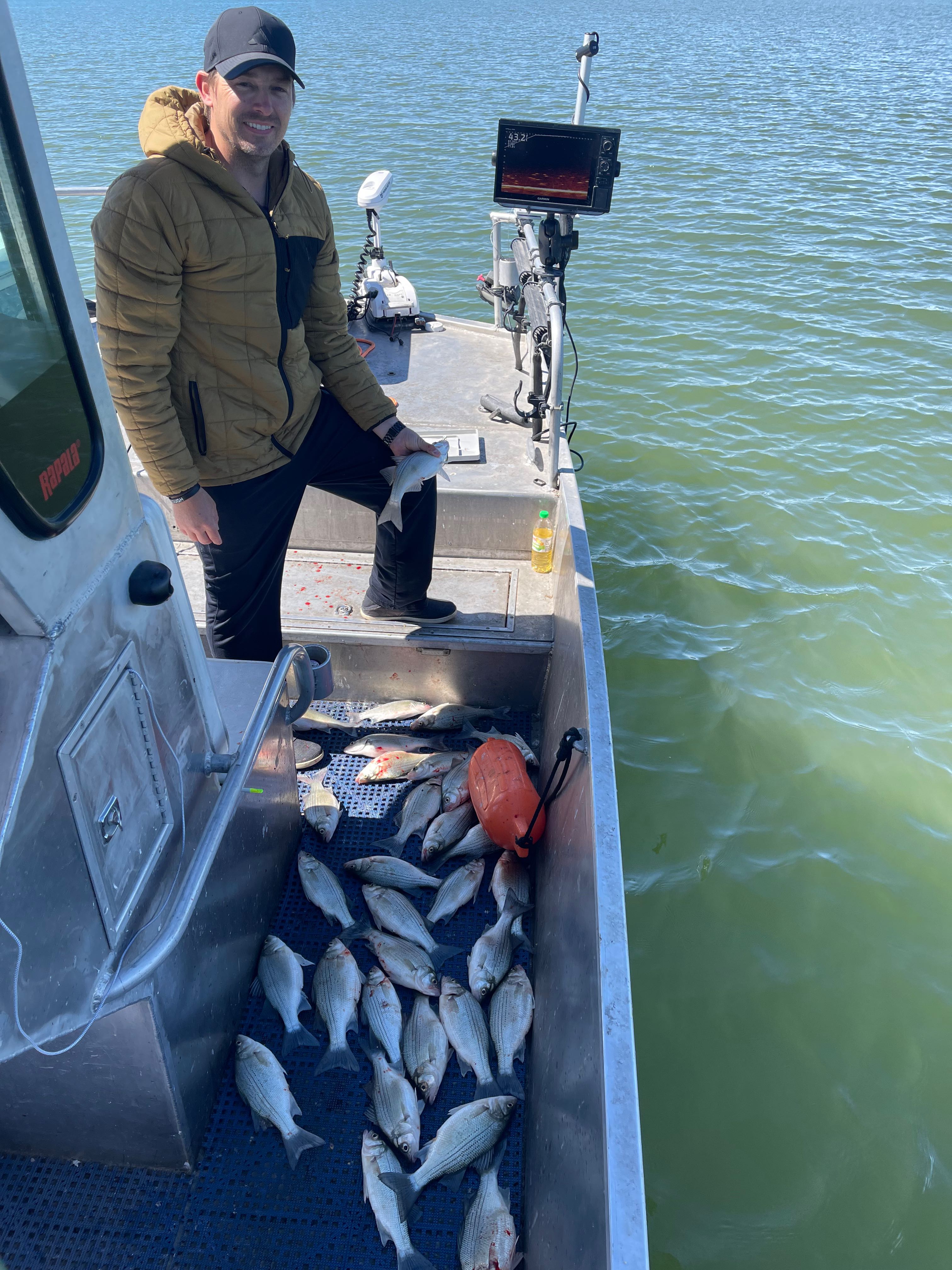 Fishing boat with large catch of fish in cooler and fish finder equipment on water in Forney TX