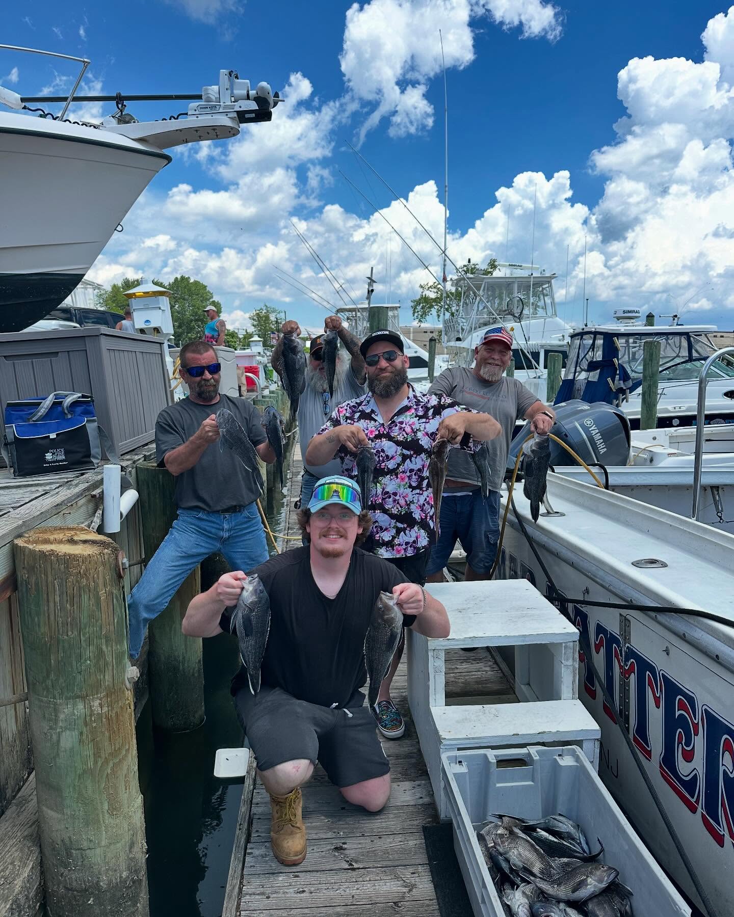 Successful black sea bass fishing trip at Neptune City NJ marina with fresh catch displayed on dock