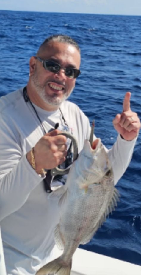 Angler holding caught fish on fishing boat in Clearwater FL waters