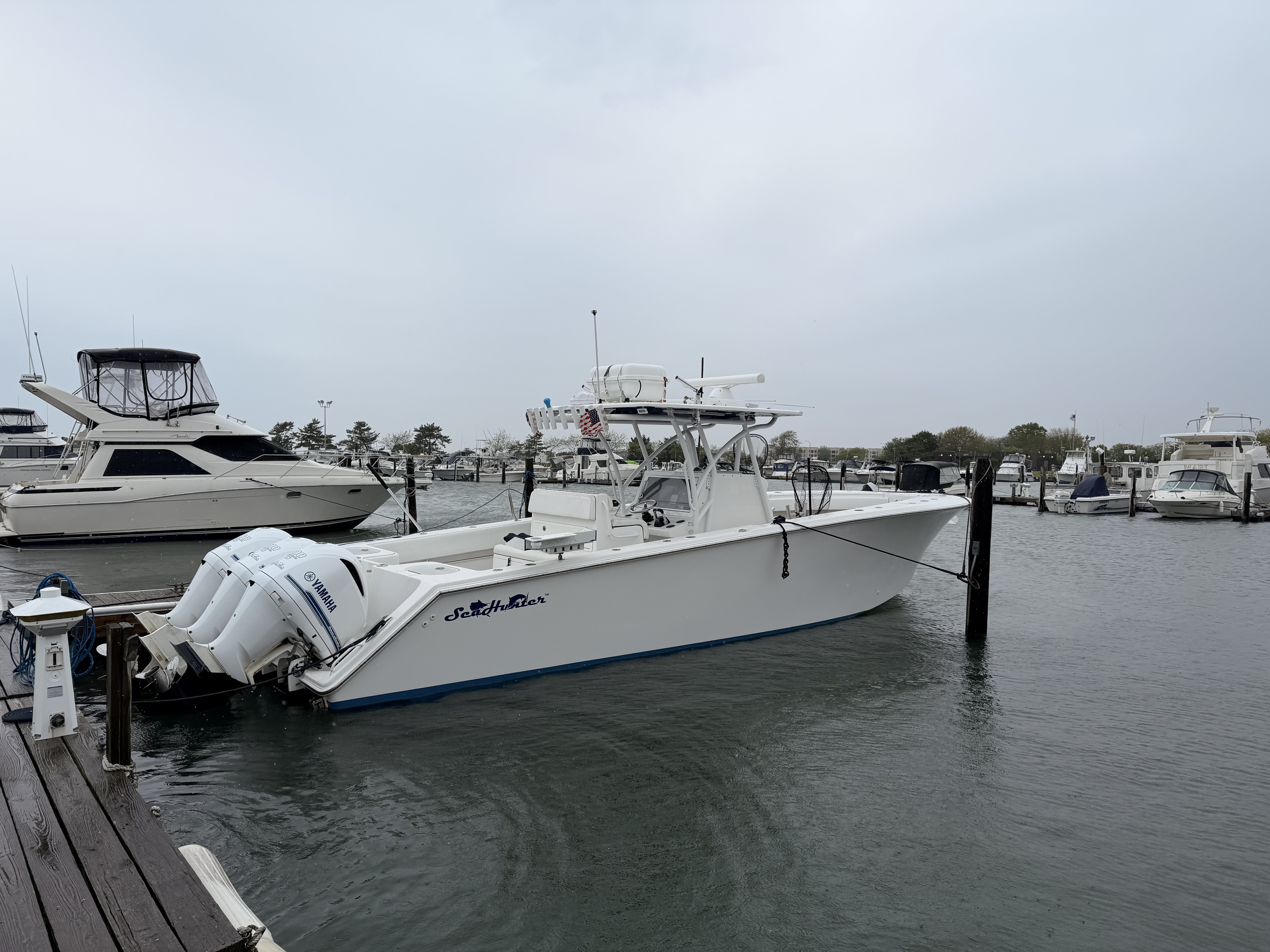 White fishing boat with twin outboard motors docked at marina in Freeport NY