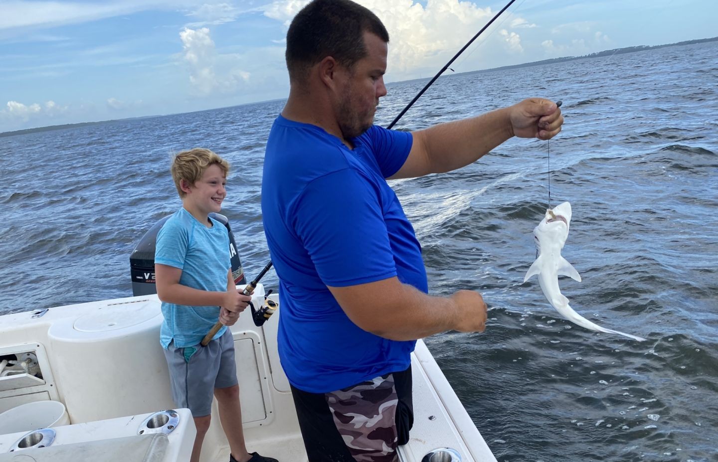 Fishing charter in Apalachicola FL with catch being held up on boat