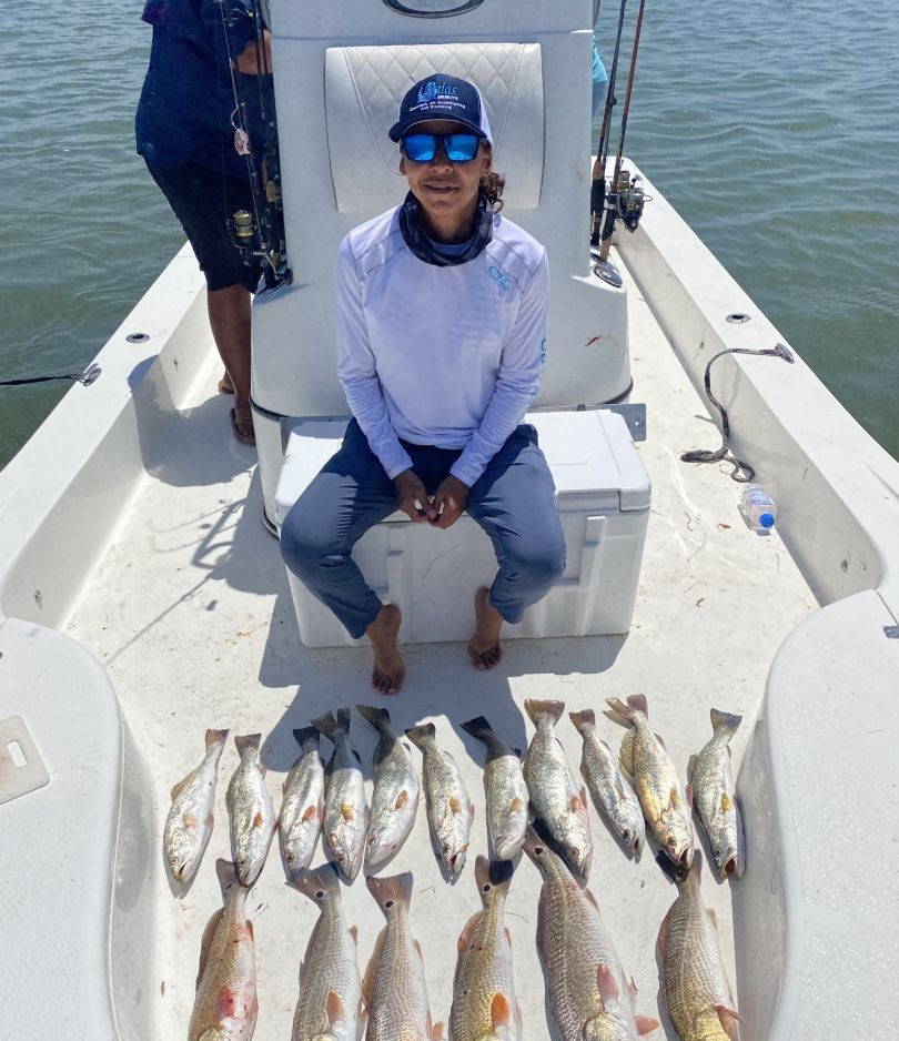 Successful redfish fishing trip displaying multiple caught redfish on boat deck at South Padre Island TX