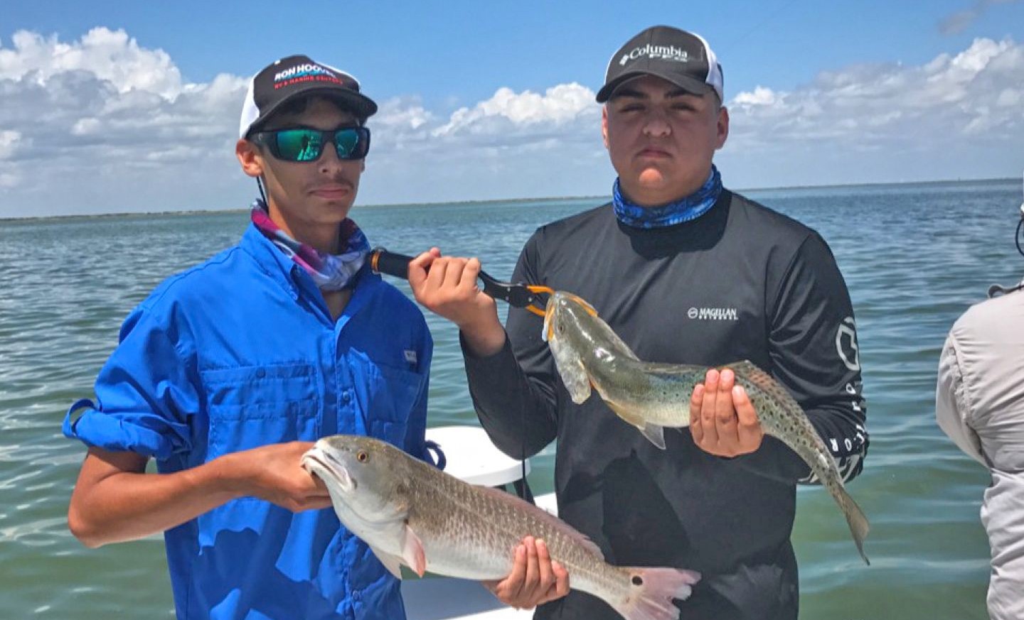 Two anglers displaying freshly caught redfish on fishing boat near South Padre Island TX