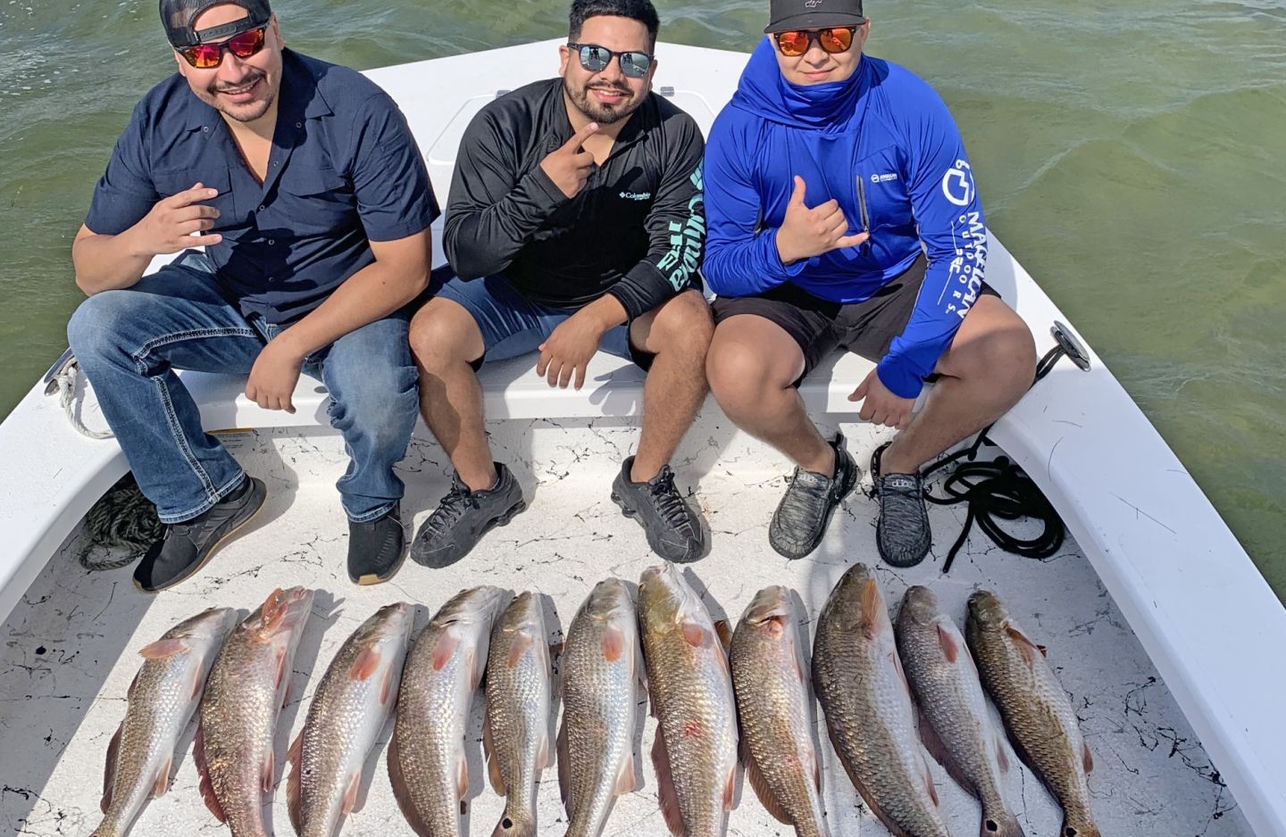 Successful redfish fishing trip on South Padre Island TX with eleven caught redfish displayed on boat deck