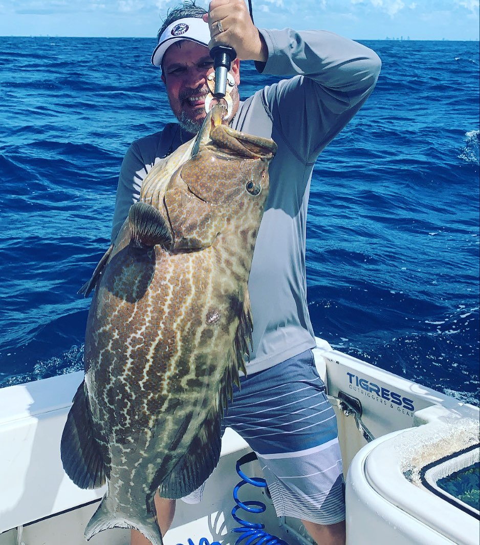 Miami reef fishing charter boat with snorkeling gear on shallow coral reefs near shore