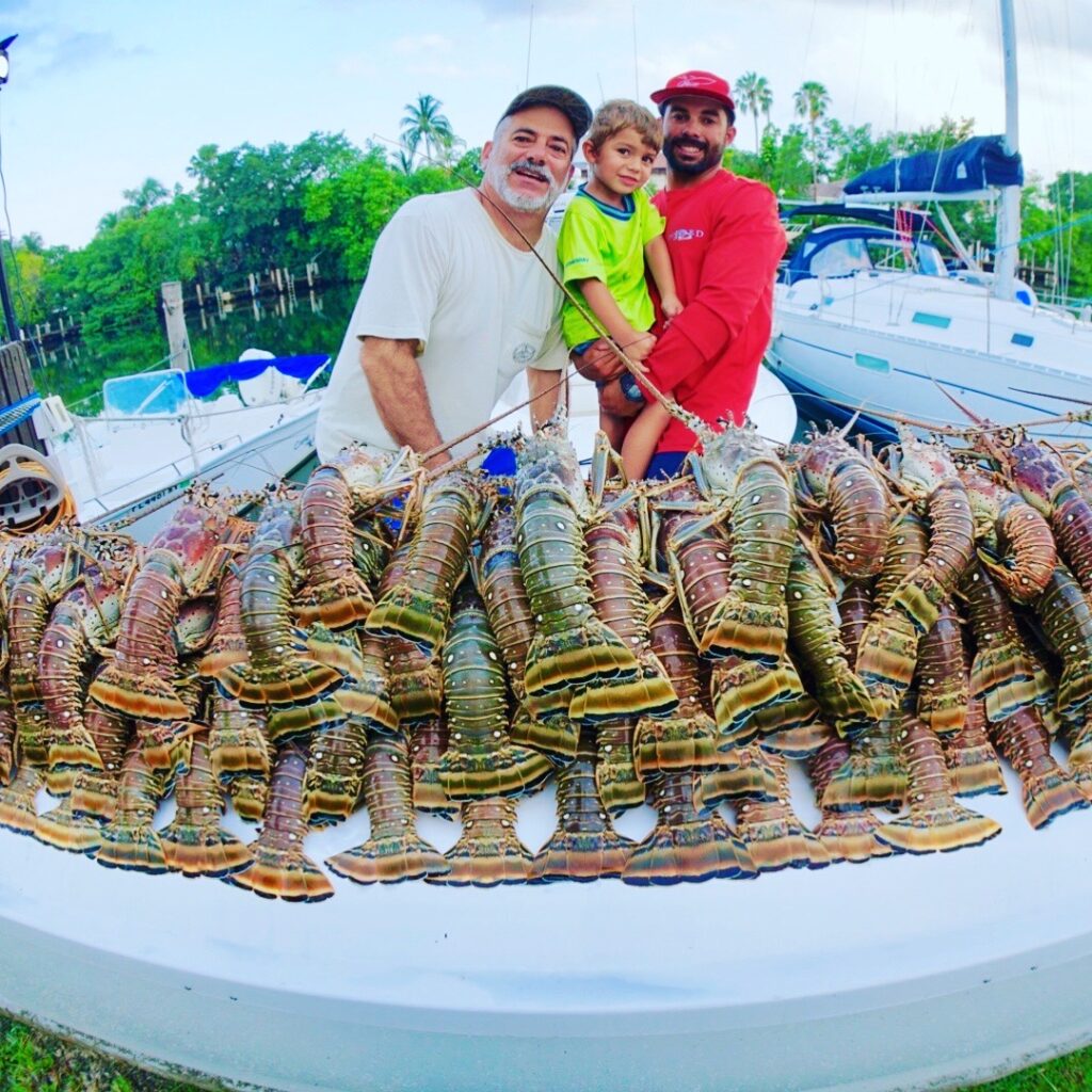 Miami lobster spearfishing charter boat on clear reef waters with diving gear and crew
