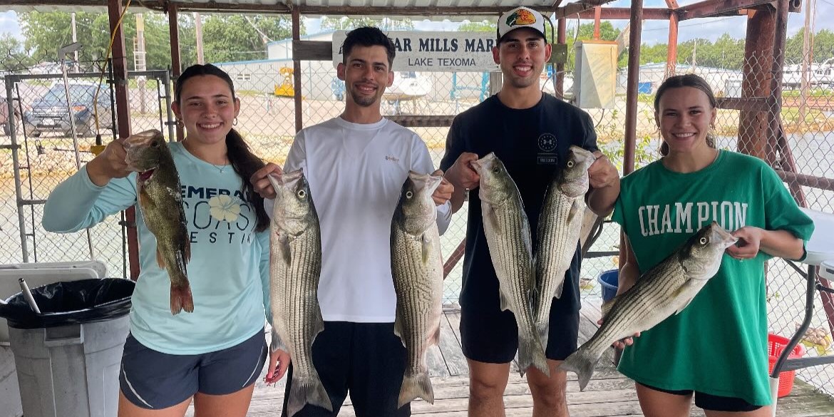 Lake Texoma striped bass fishing guide boat with 4 anglers using rods and tackle on water