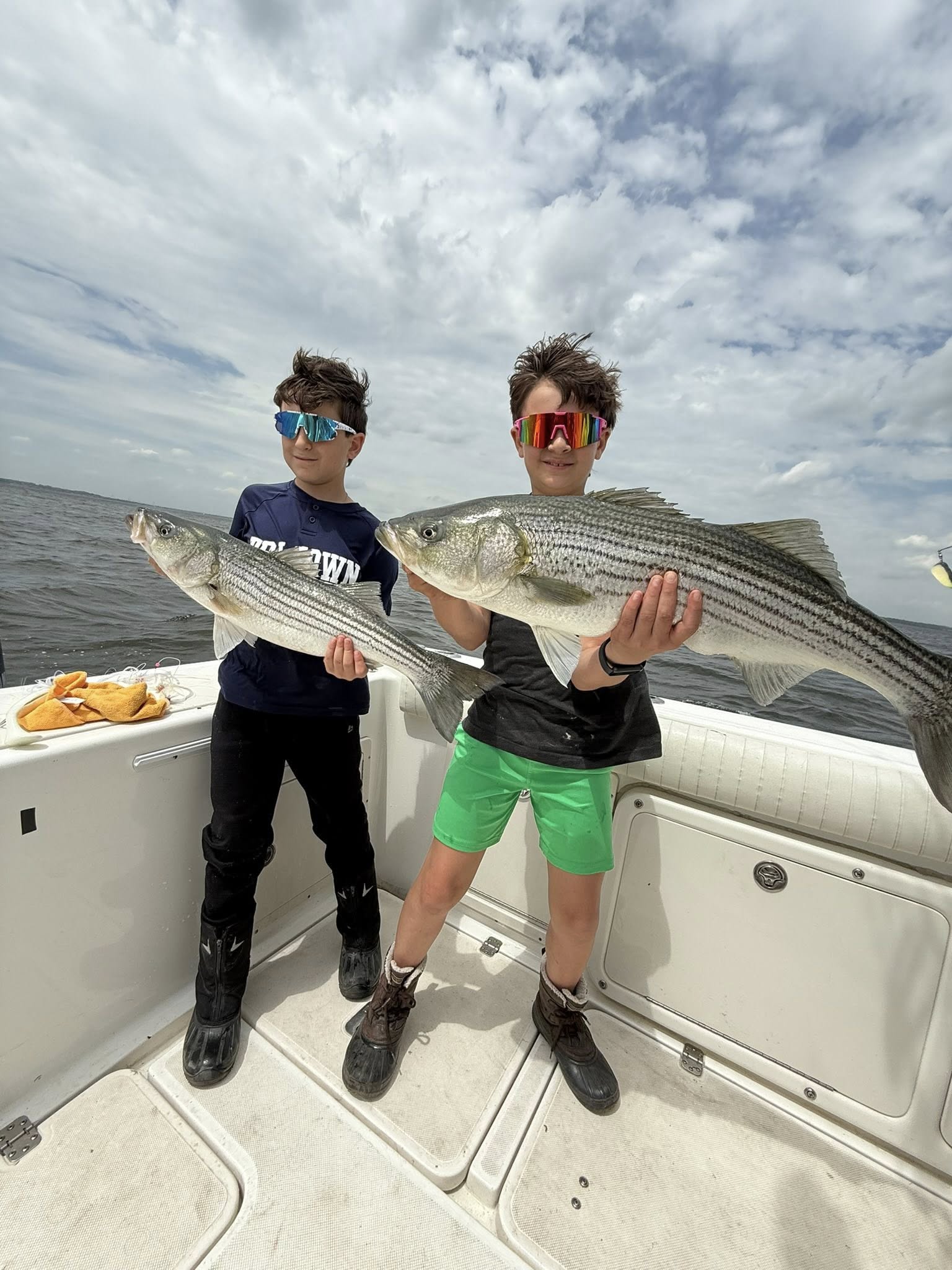 Two striped bass caught fishing at Point Pleasant Beach NJ displayed on boat deck