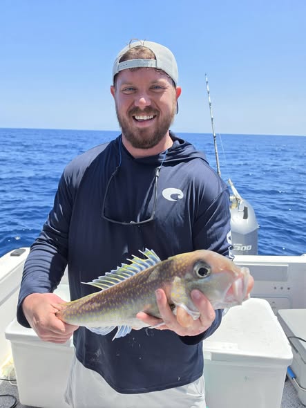 Angler holding caught fish on fishing boat in Orange Beach AL waters