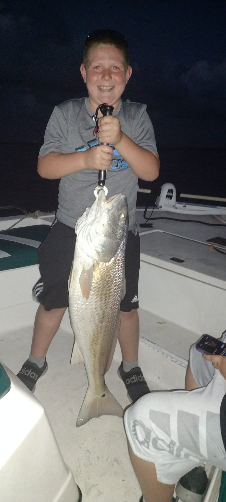 Large redfish caught while fishing in Texas City TX displayed on boat deck at night